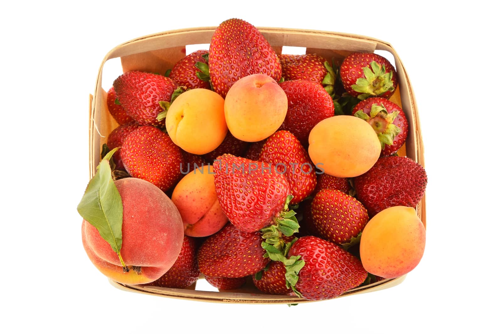 Strawberries, apricots and peach in wooden basket isolated on wh by BreakingTheWalls
