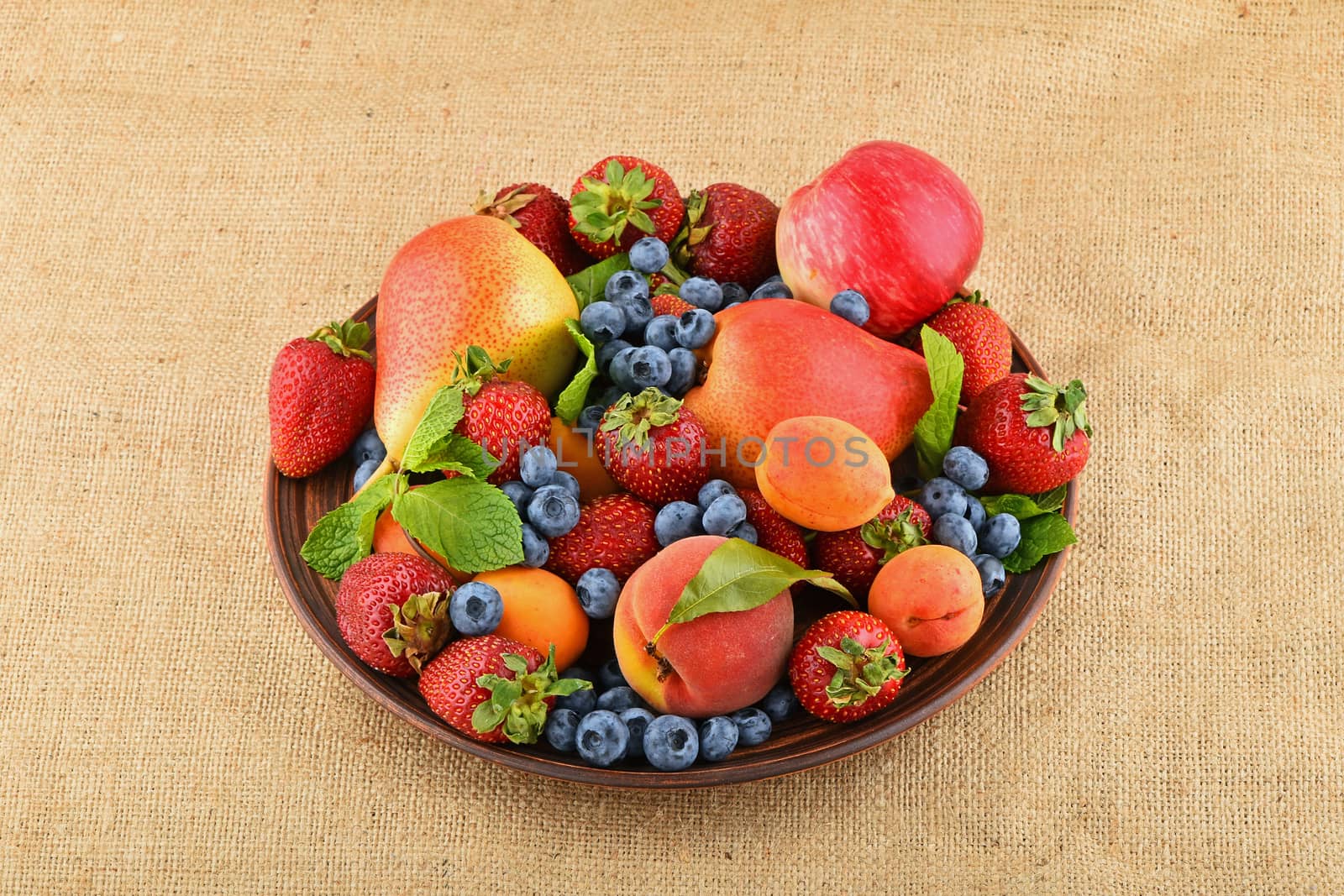 Fruits and berries mix in ceramic plate on burlap canvas by BreakingTheWalls