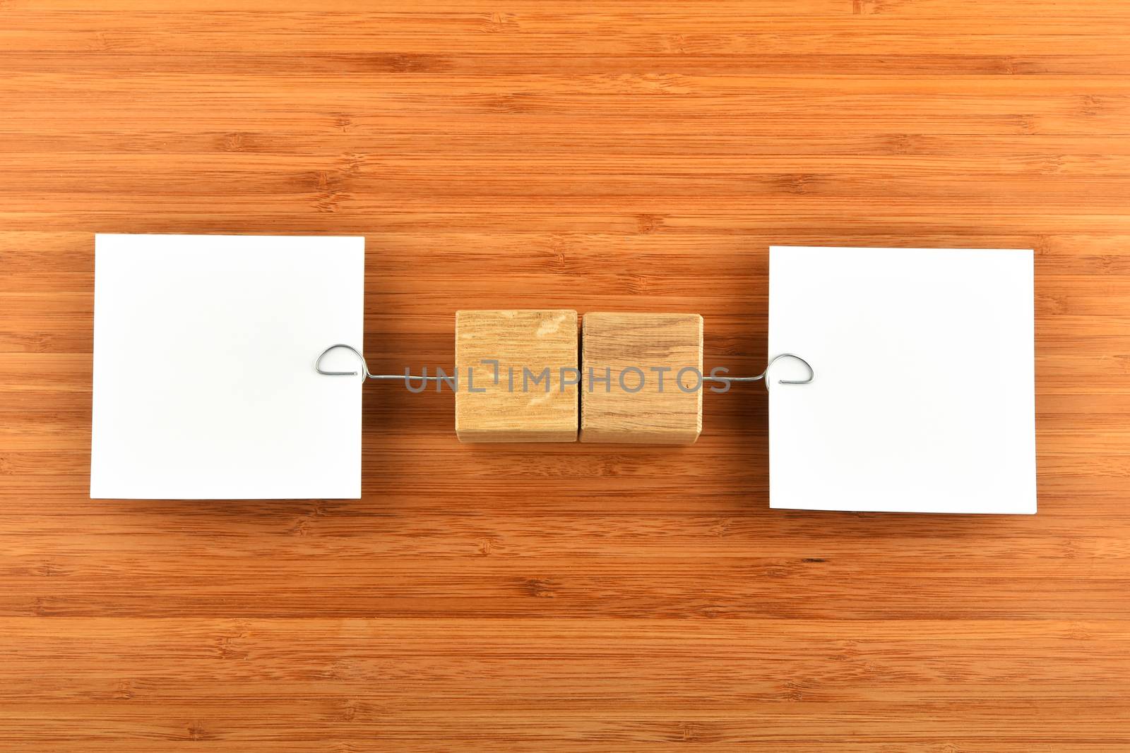 Opposite Opinions - Two white paper notes with wooden holders in different directions on bamboo wooden background for presentation