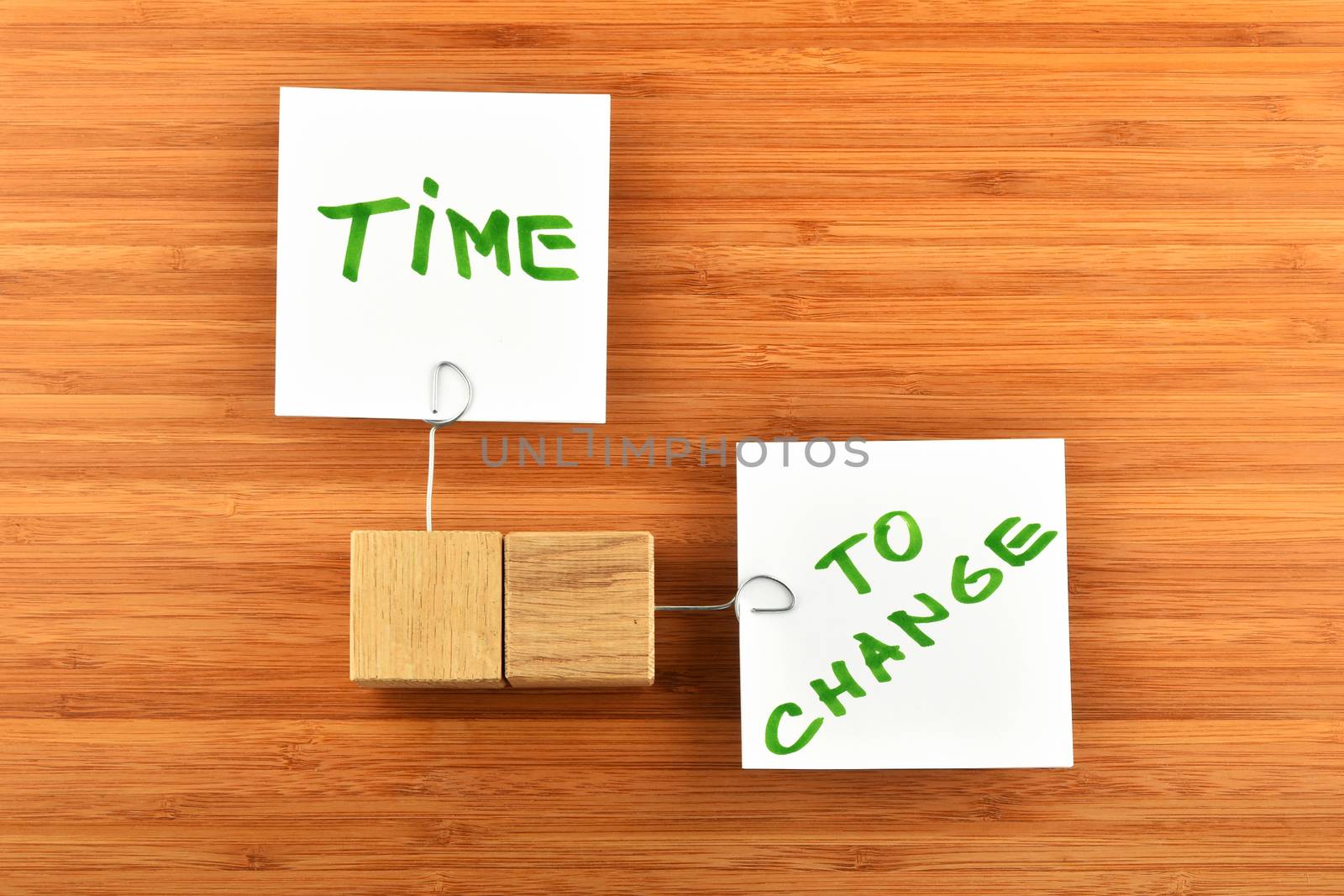 Time to change, two white paper notes with wooden holders in different directions on wooden bamboo background for presentation
