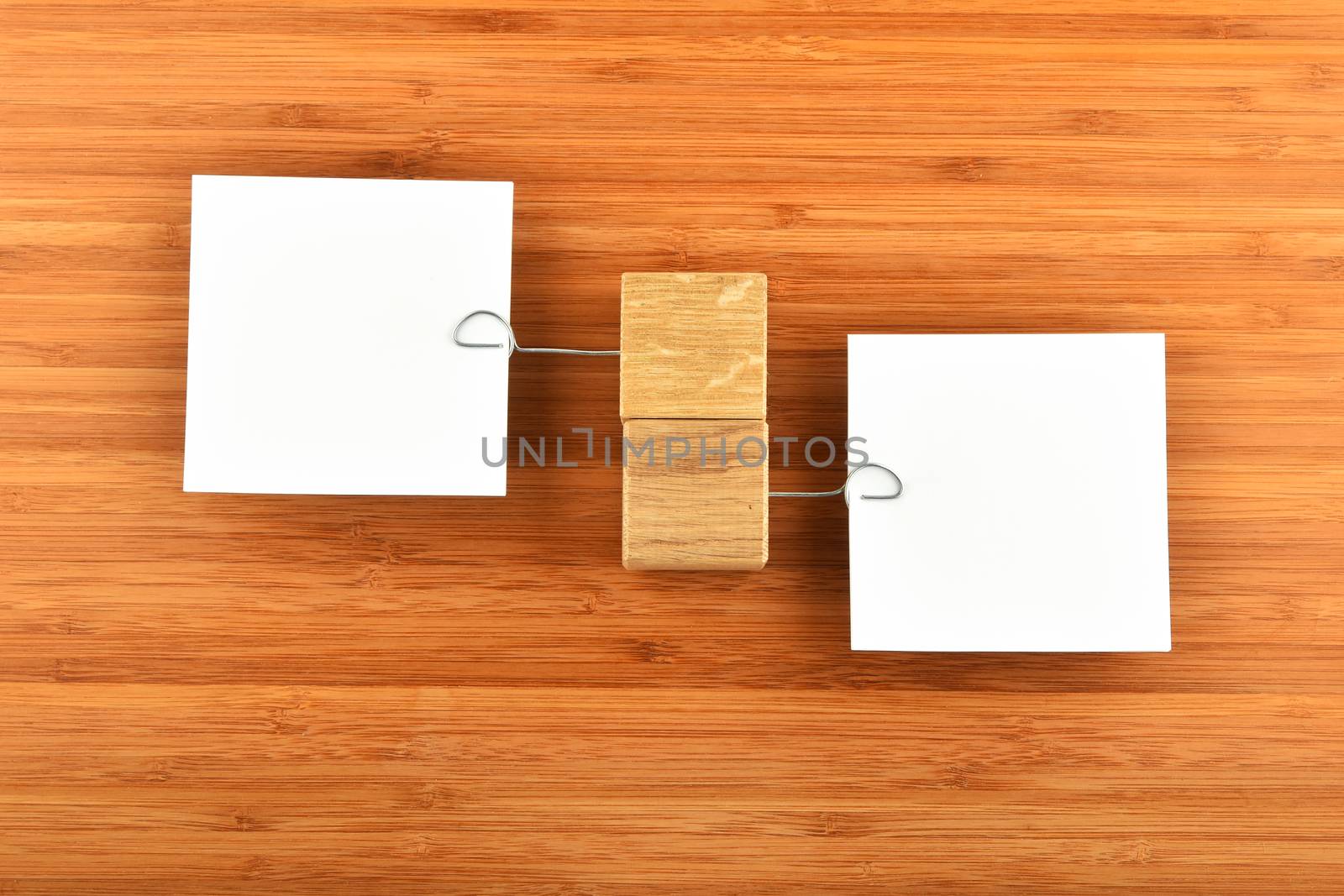 Opposite Opinion - Two white paper notes with wooden holders in different directions on wooden bamboo background for presentation