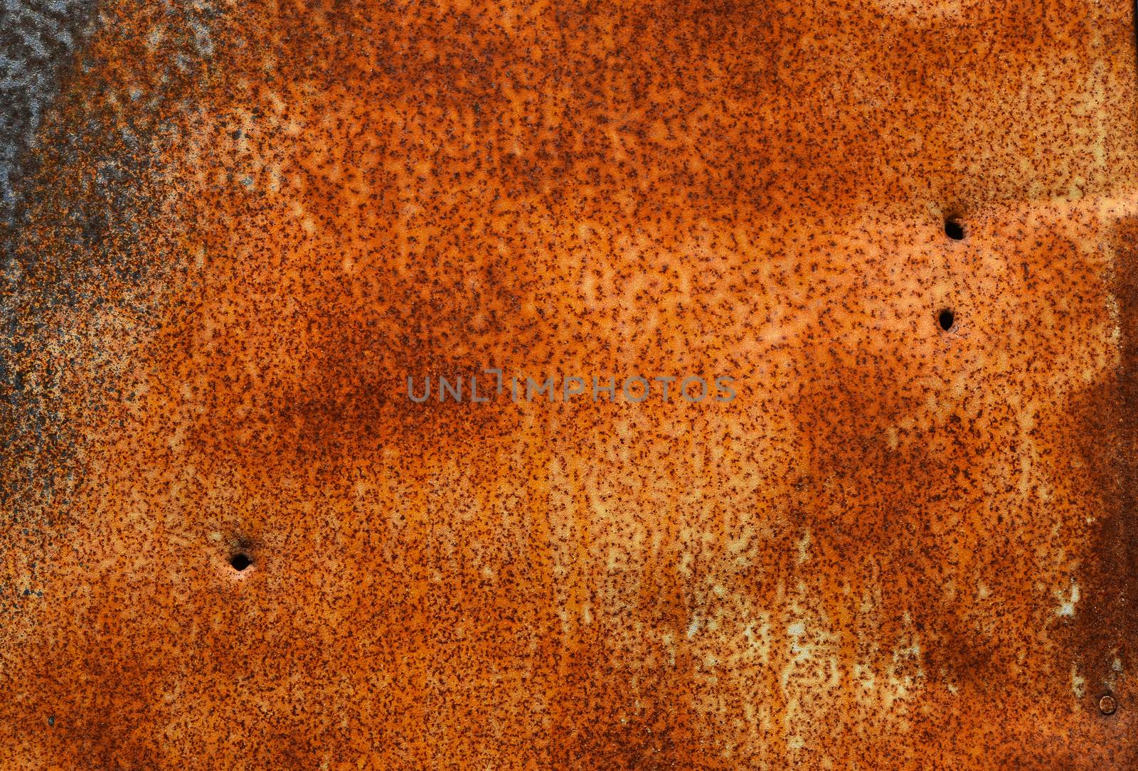 Old vintage bright rust stained corroded metal surface with dark corroded corner and hole