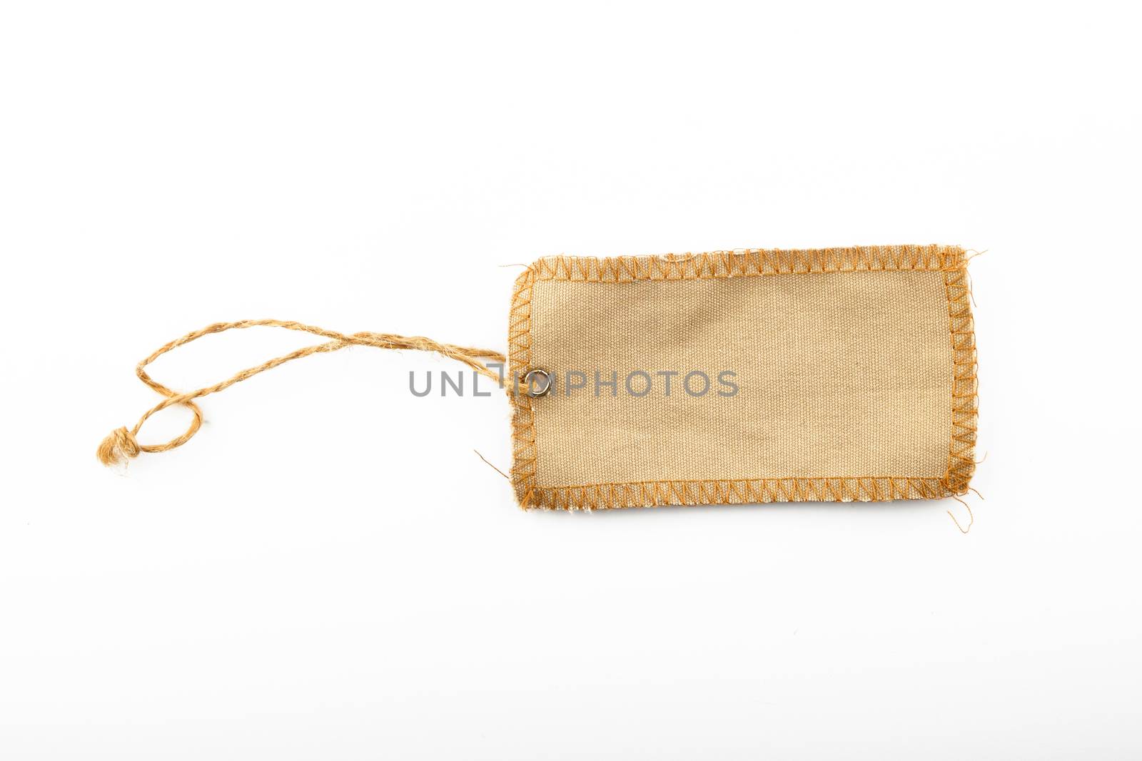 Blank canvas label tag overlocked with jute rope and metal rivet isolated on white