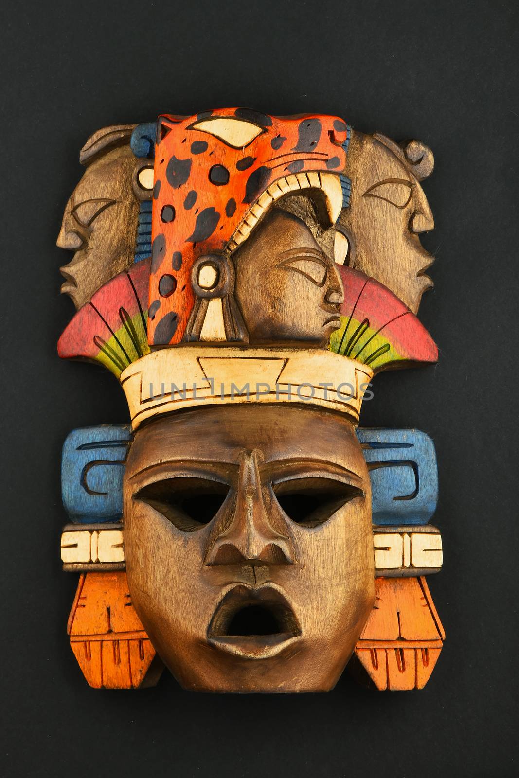 Indian Mayan Aztec wooden carved painted mask isolated on black by BreakingTheWalls