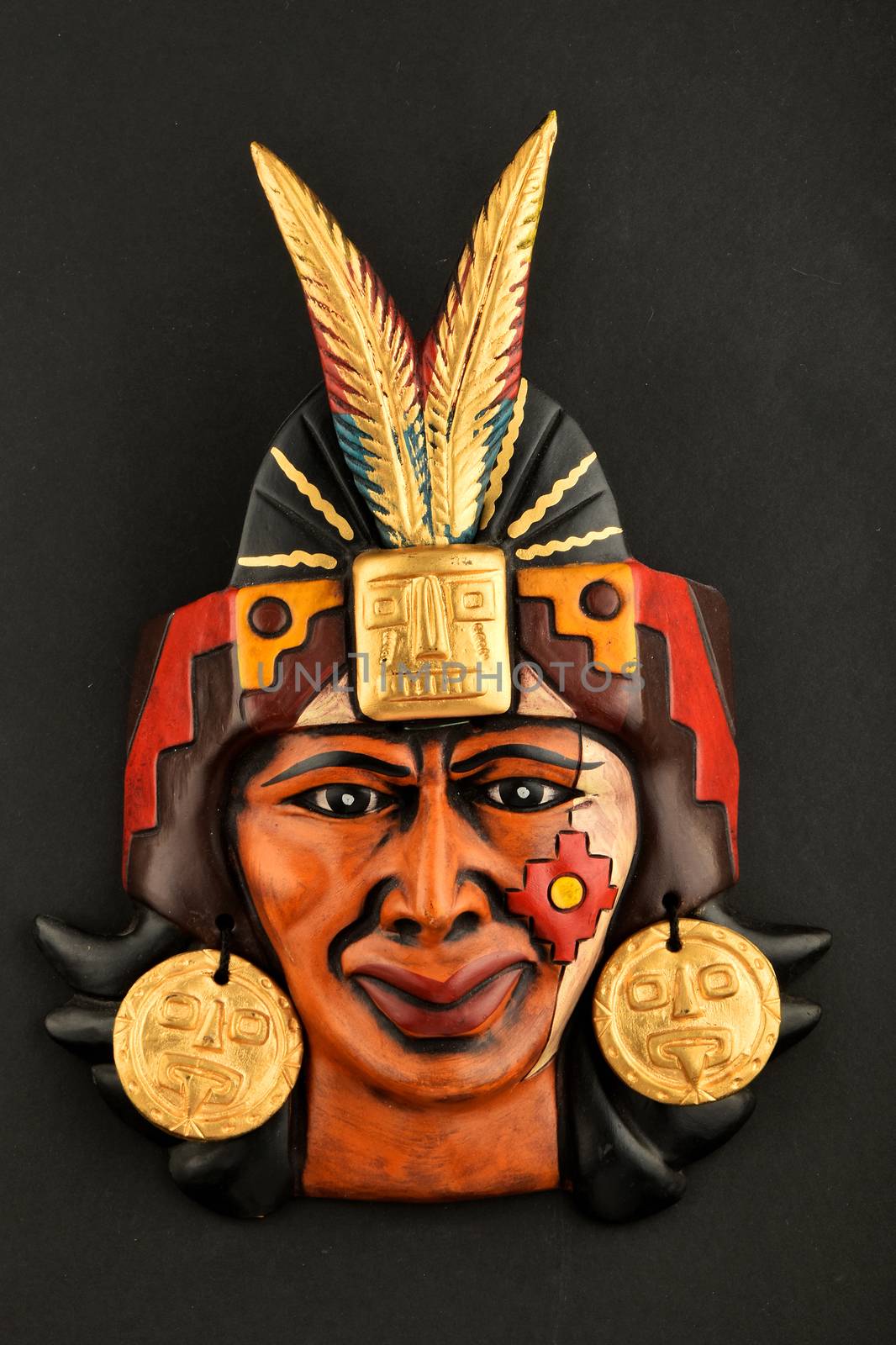 Indian Mayan Aztec ceramic mask with feather isolated on black by BreakingTheWalls