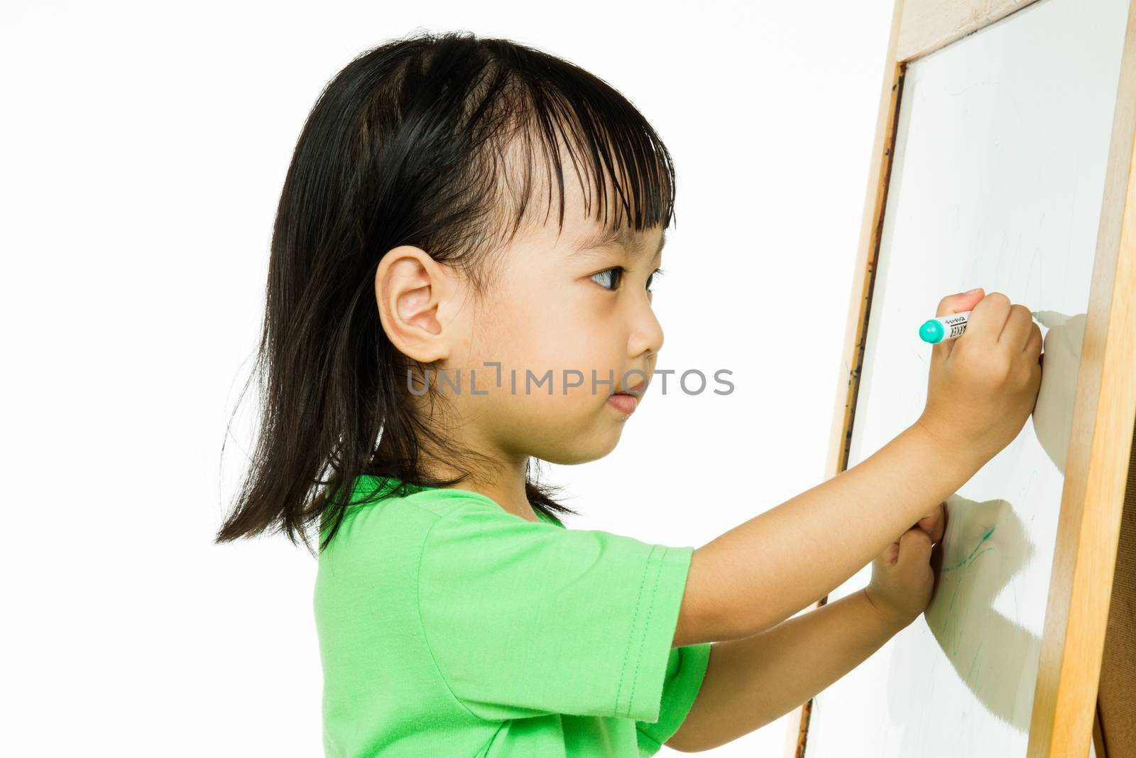 Happy cute Asian Chinese toddler girl drawing or writting with marker pen on a blank whiteboard at home, preschool, daycare or kindergarten in plain white isolated background.