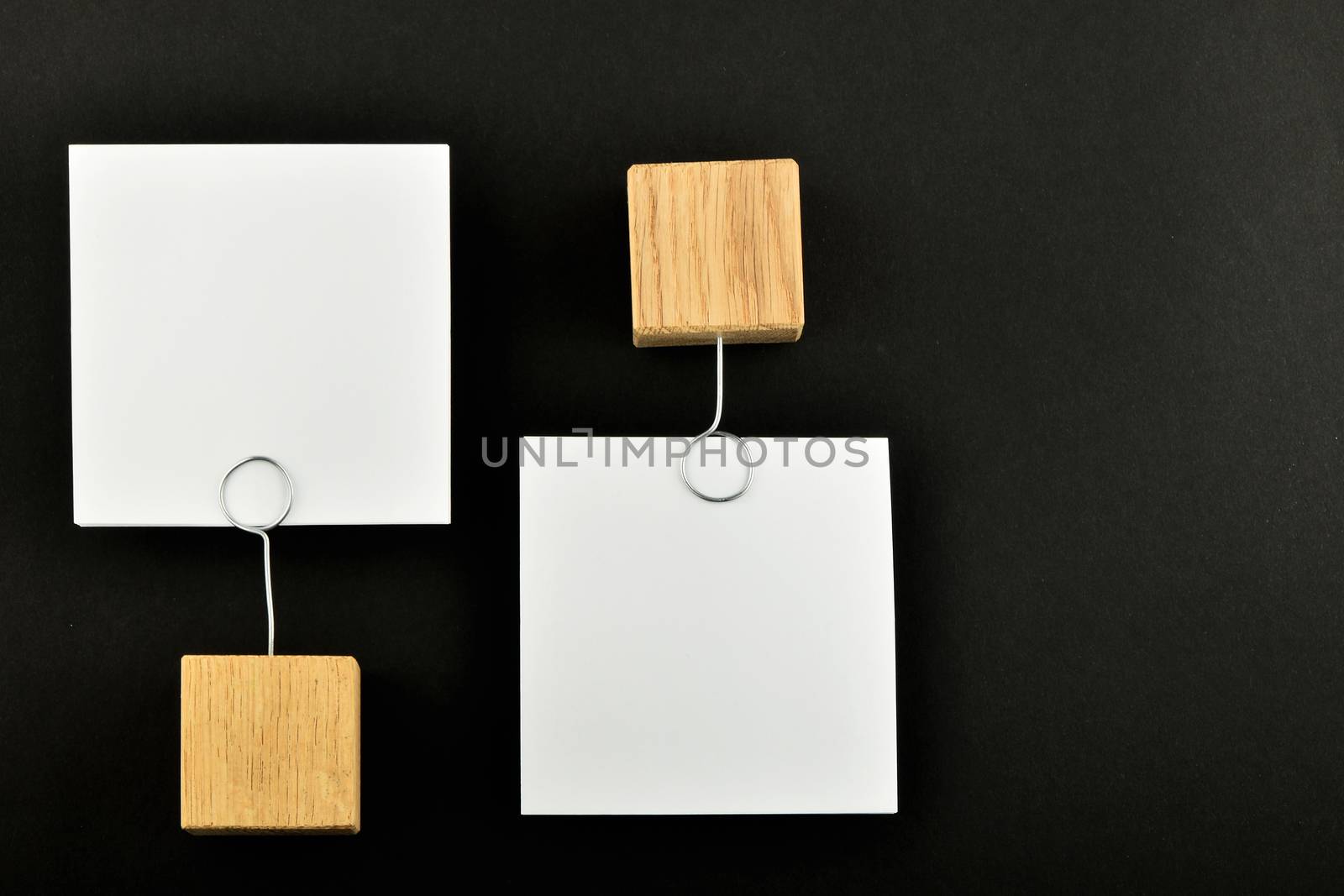 Opposite Opinion - Two white paper notes with wooden holders in different directions isolated on black paper background for presentation