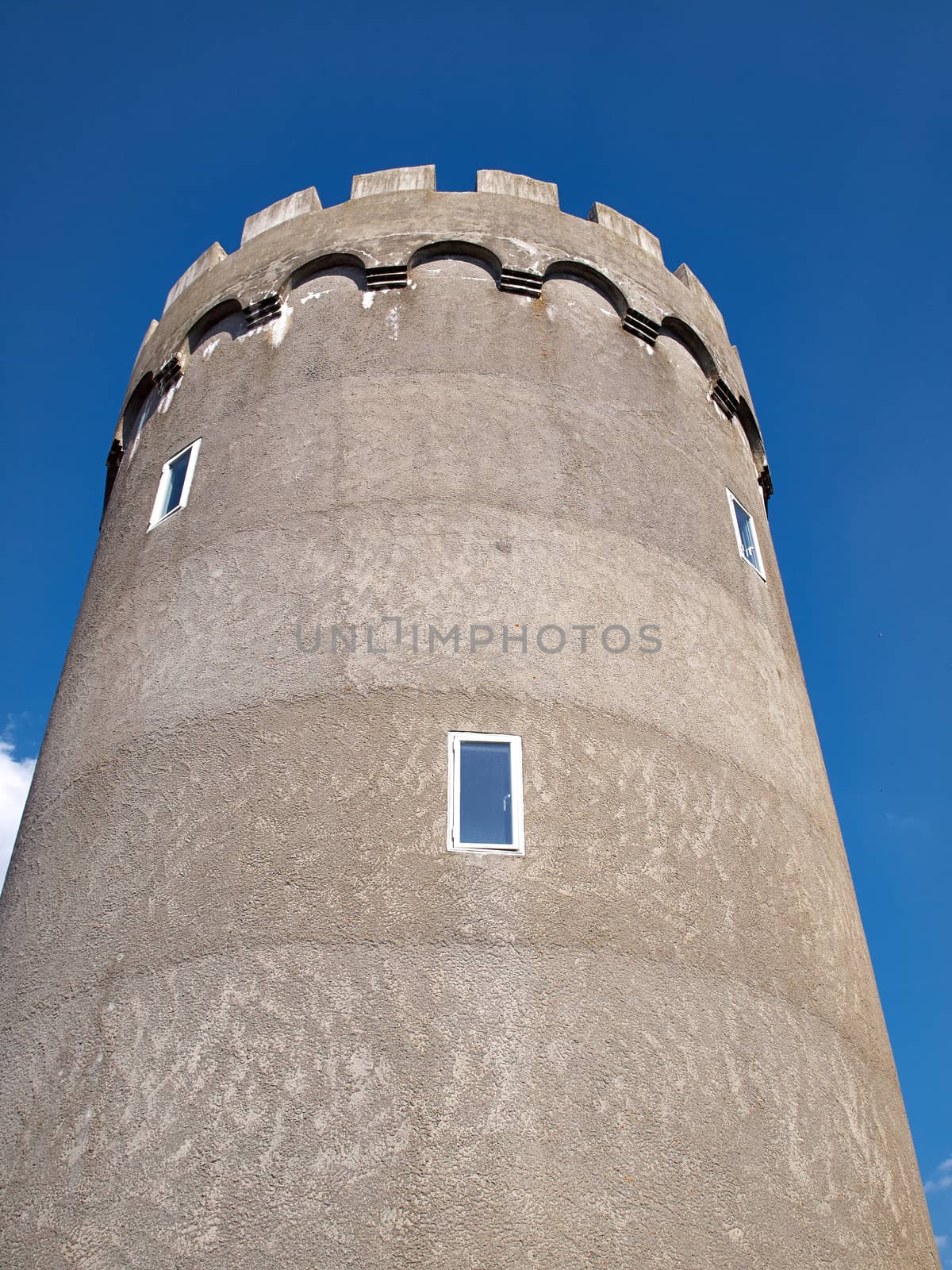 Old concrete city water tower with clear blue sky background vertical image