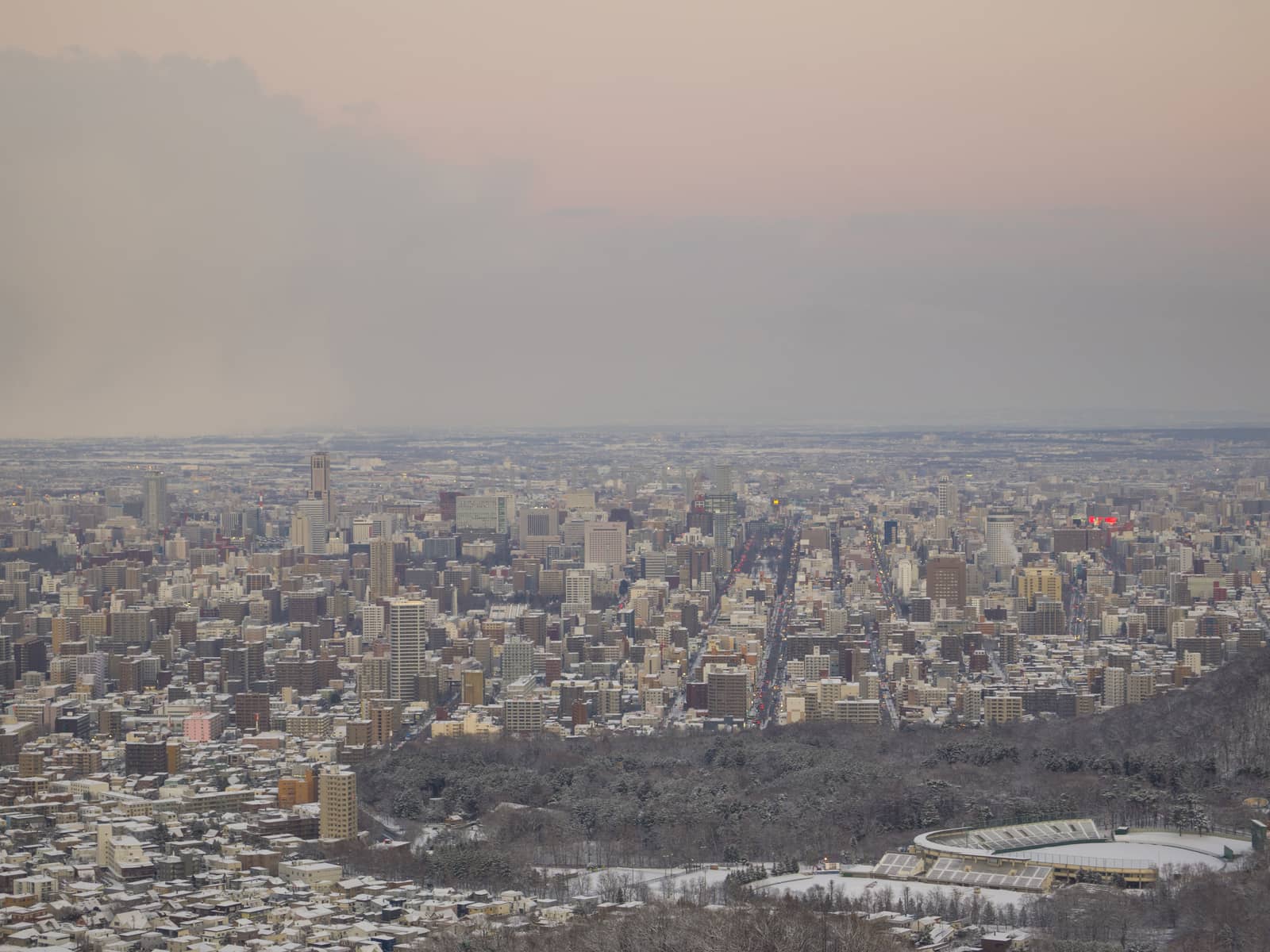 Sapporo city in evening, view from the summit of Mount Okura in winter.