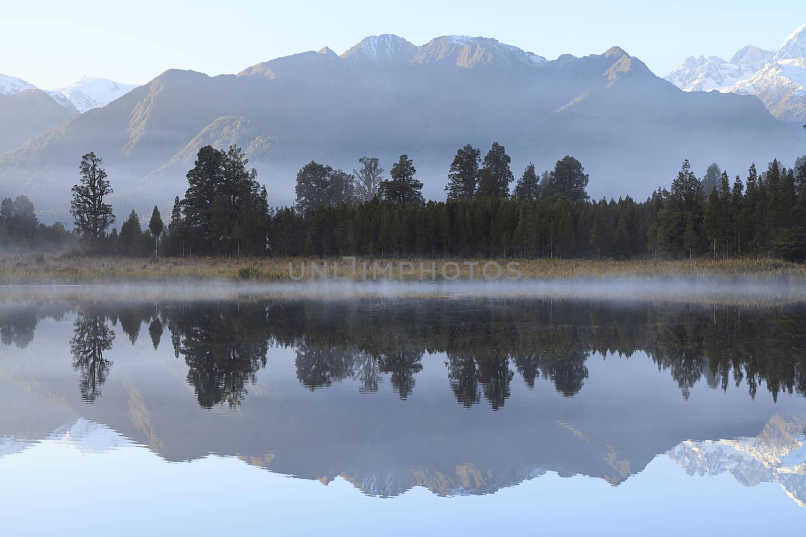 Reflection of Lake Matheson with Mount Cook and Mount Tasman as background, West Coast region, South Island, New Zealand.