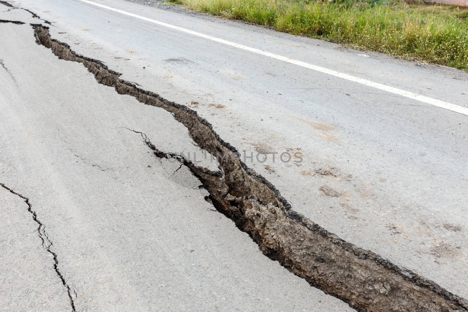 Cracked and broken asphalt road from earthquake.