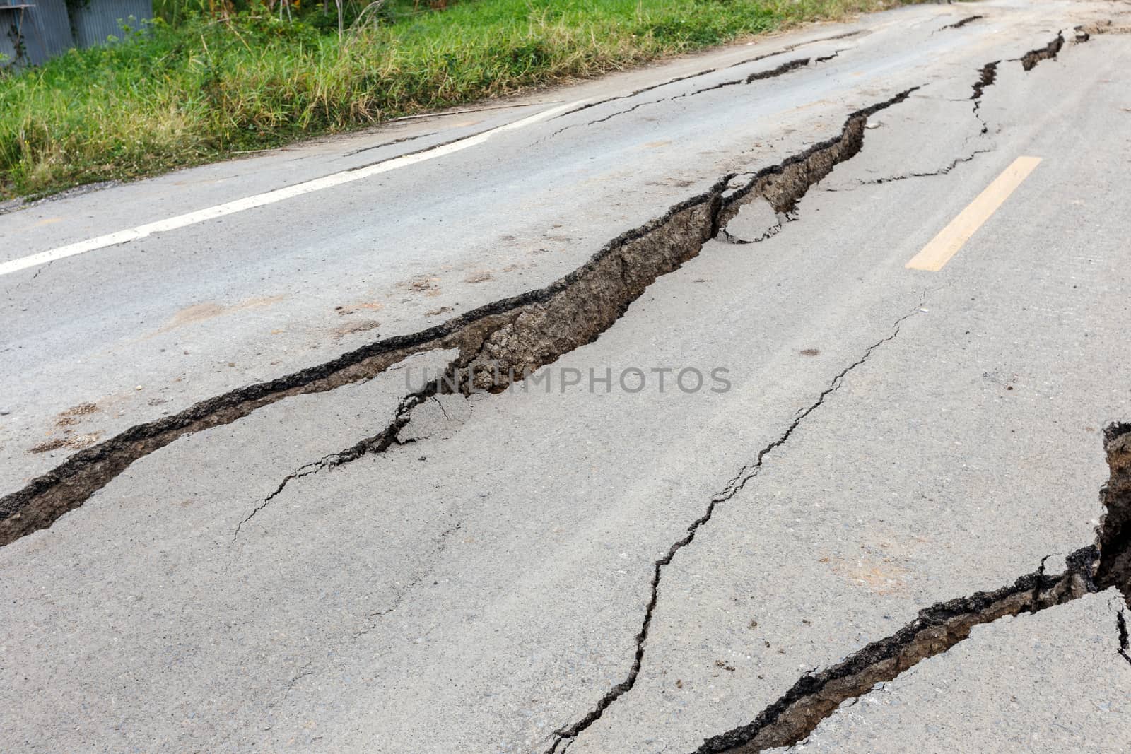 Cracked and broken asphalt road from earthquake.