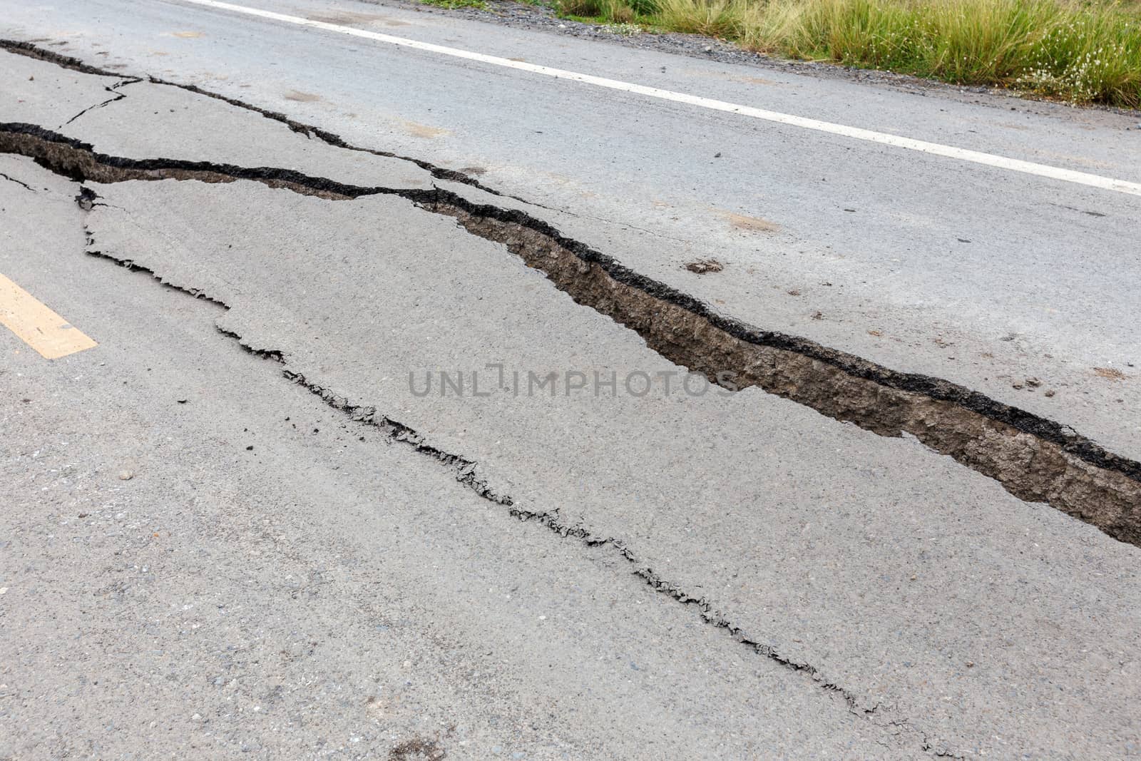 Cracked and broken asphalt road from earthquake.