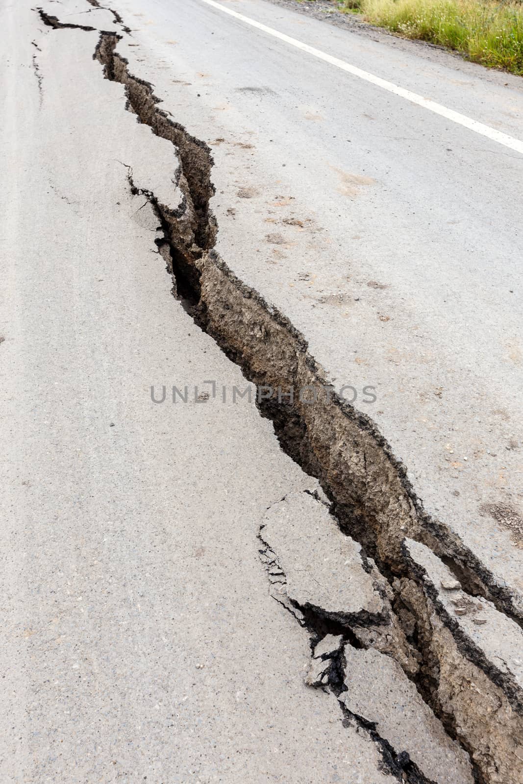 Cracked and broken asphalt road from earthquake.