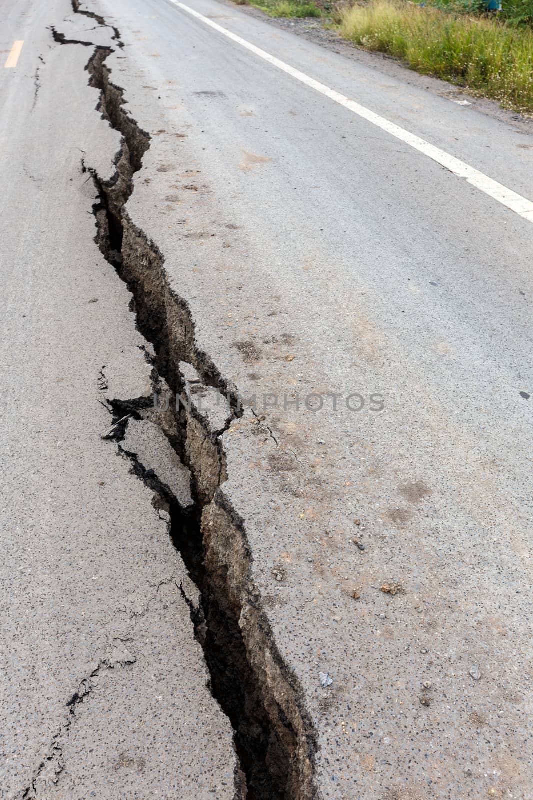 Cracked and broken asphalt road from earthquake.