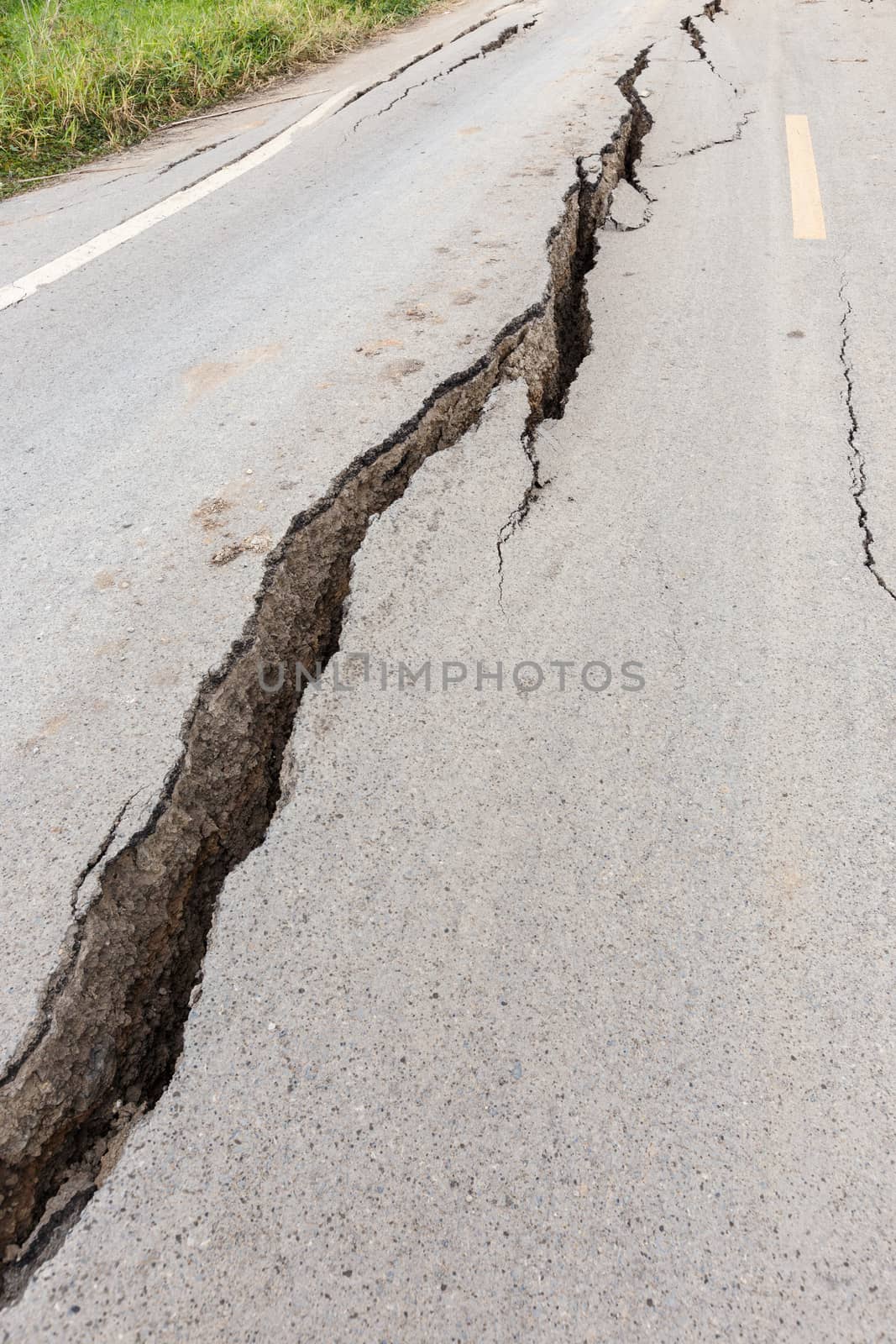 Cracked and broken asphalt road from earthquake.