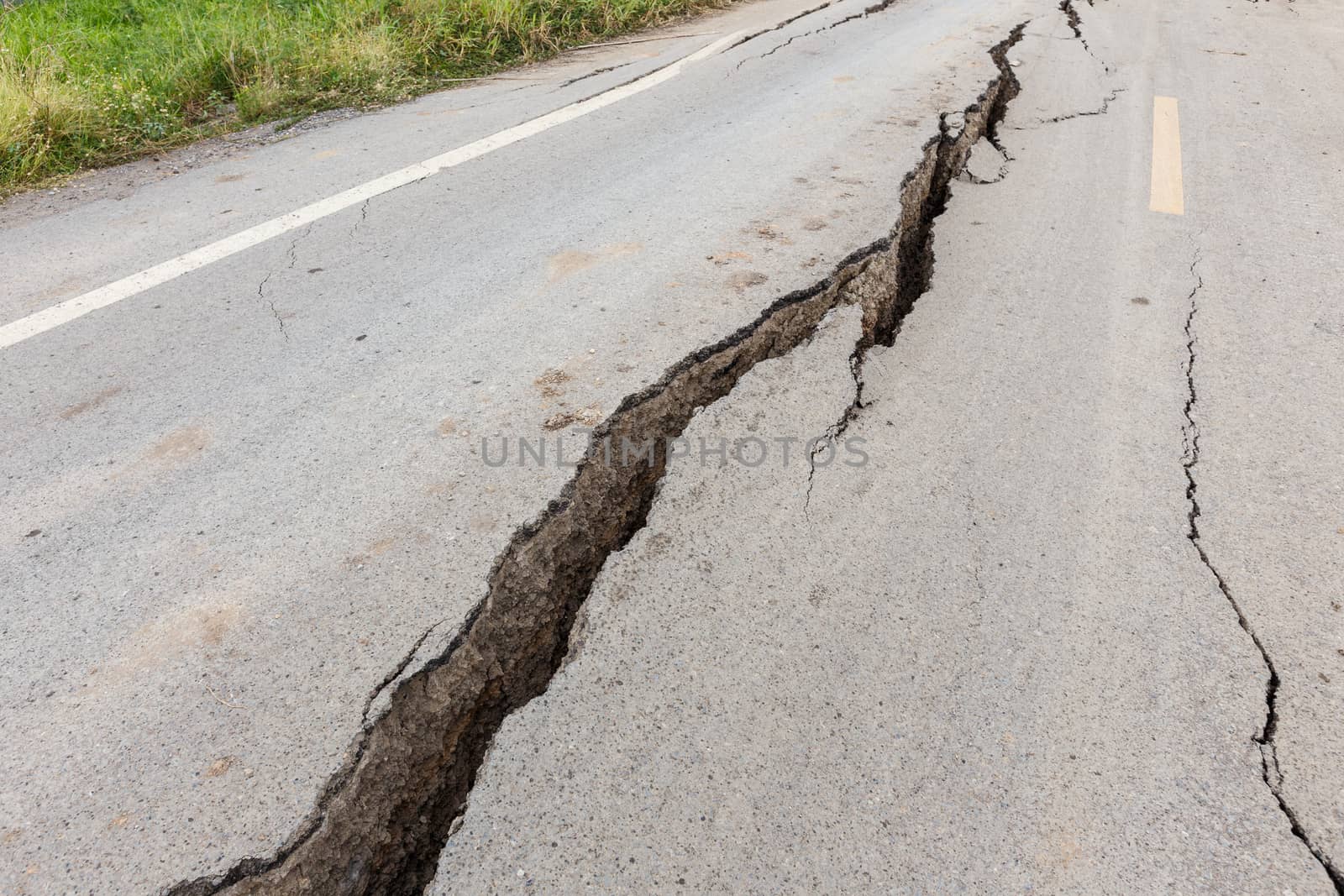 Cracked and broken asphalt road from earthquake.