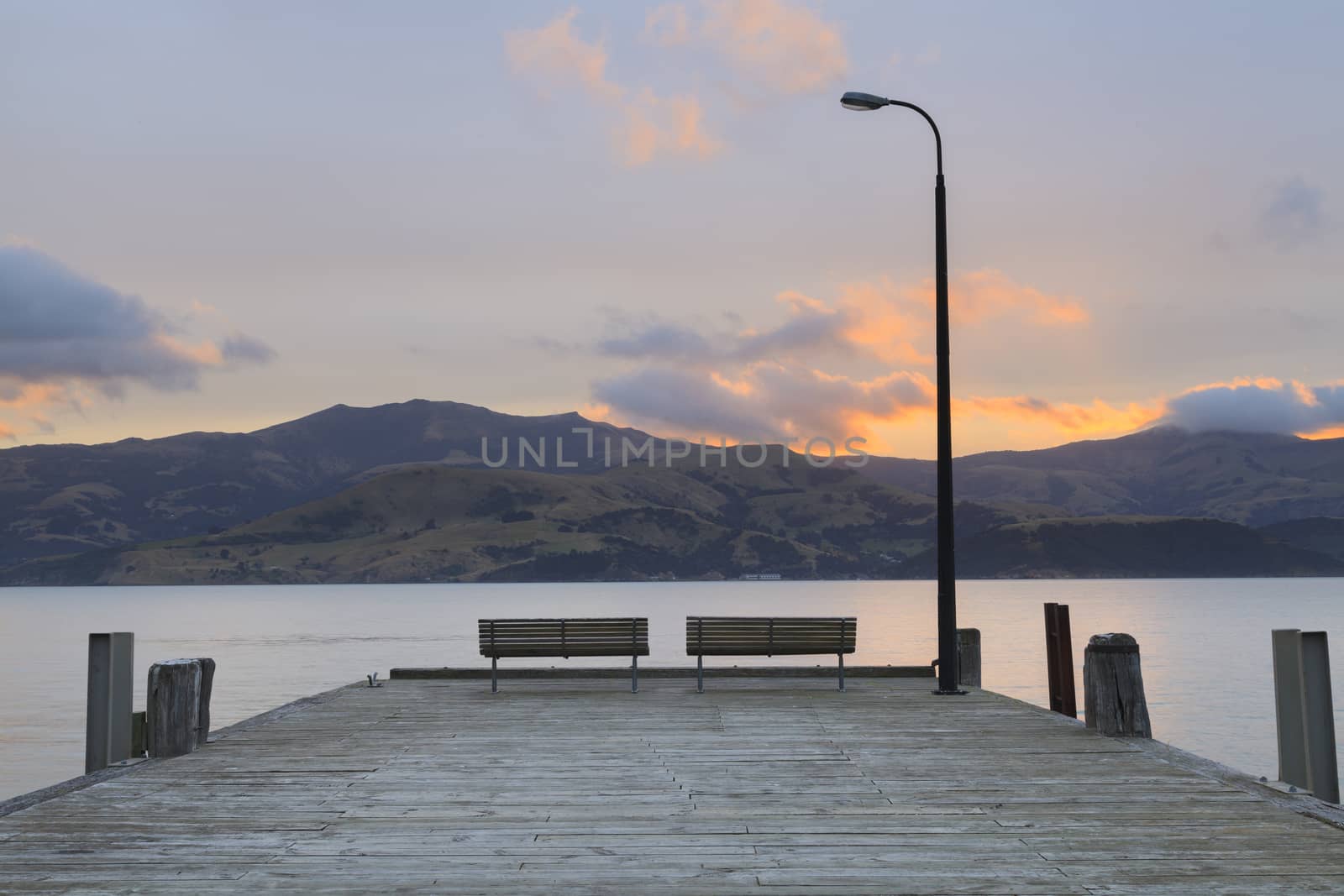 Sunset at Wooden pier in Akaroa, Canterbury region, South Island, New Zealand.