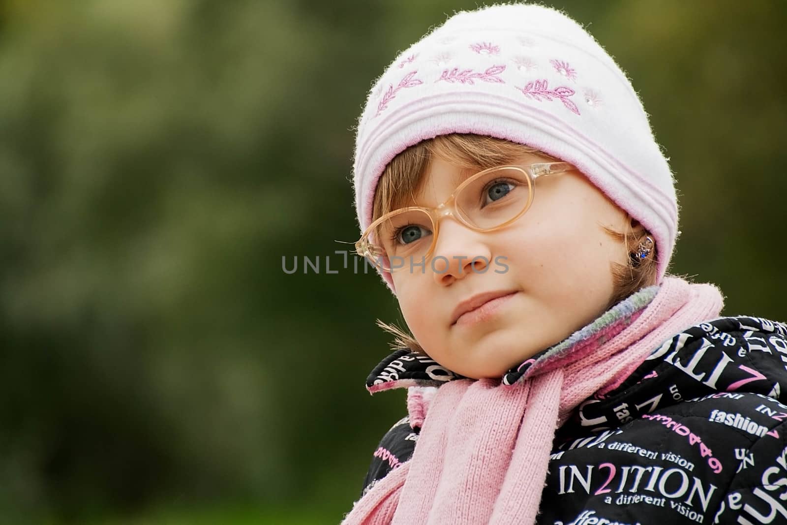 cute child girl in glasses sits on a Park bench by alexx60