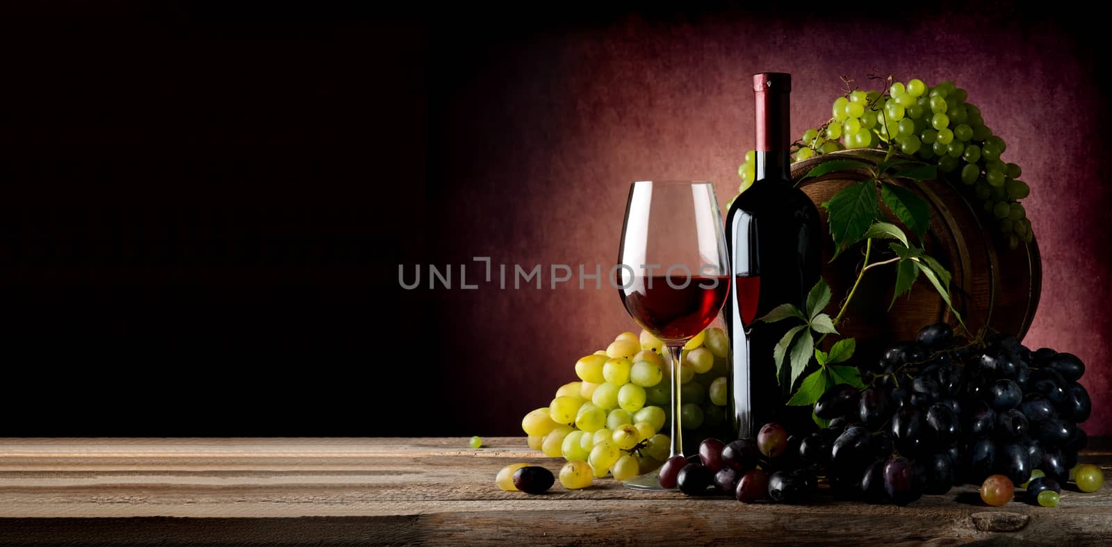 Vine of grape with wine on wooden table