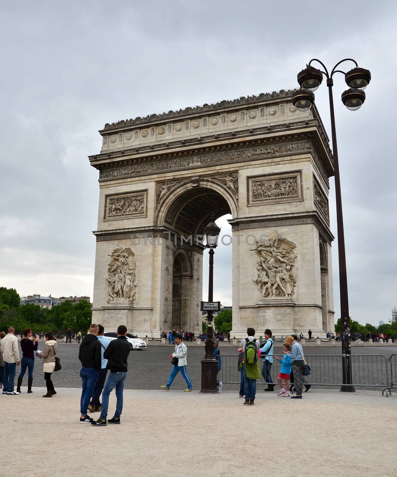 Paris, France - May 14, 2015: Tourist visit Arc de Triomphe in Paris. Arc de Triomphe was built in 1806-1836 by architect Jean Shalgrenom by order of Napoleon to commemorate victories of his Army.