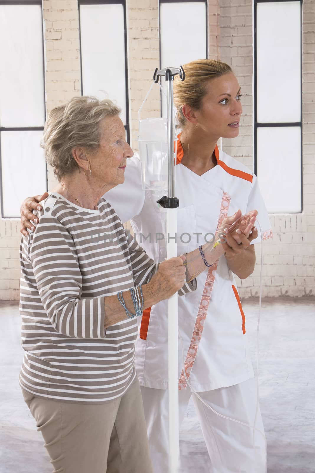 Nurse walking next to a patient with IV drip in hospital