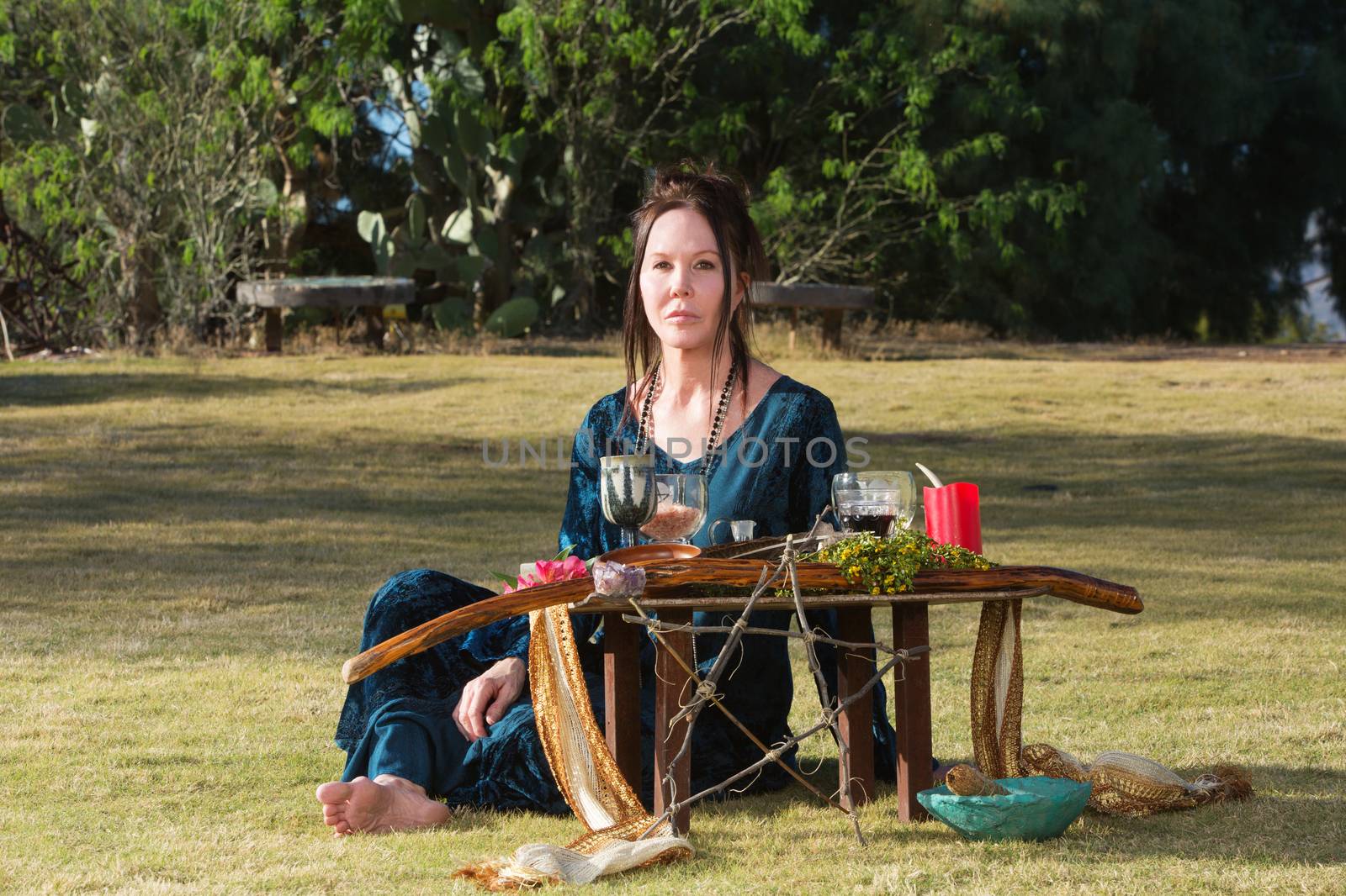 Serious priestess in outdoor pagan altar ceremony