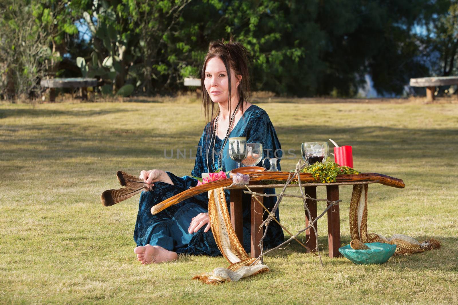 Caucasian adult outdoors with feather and pagan altar