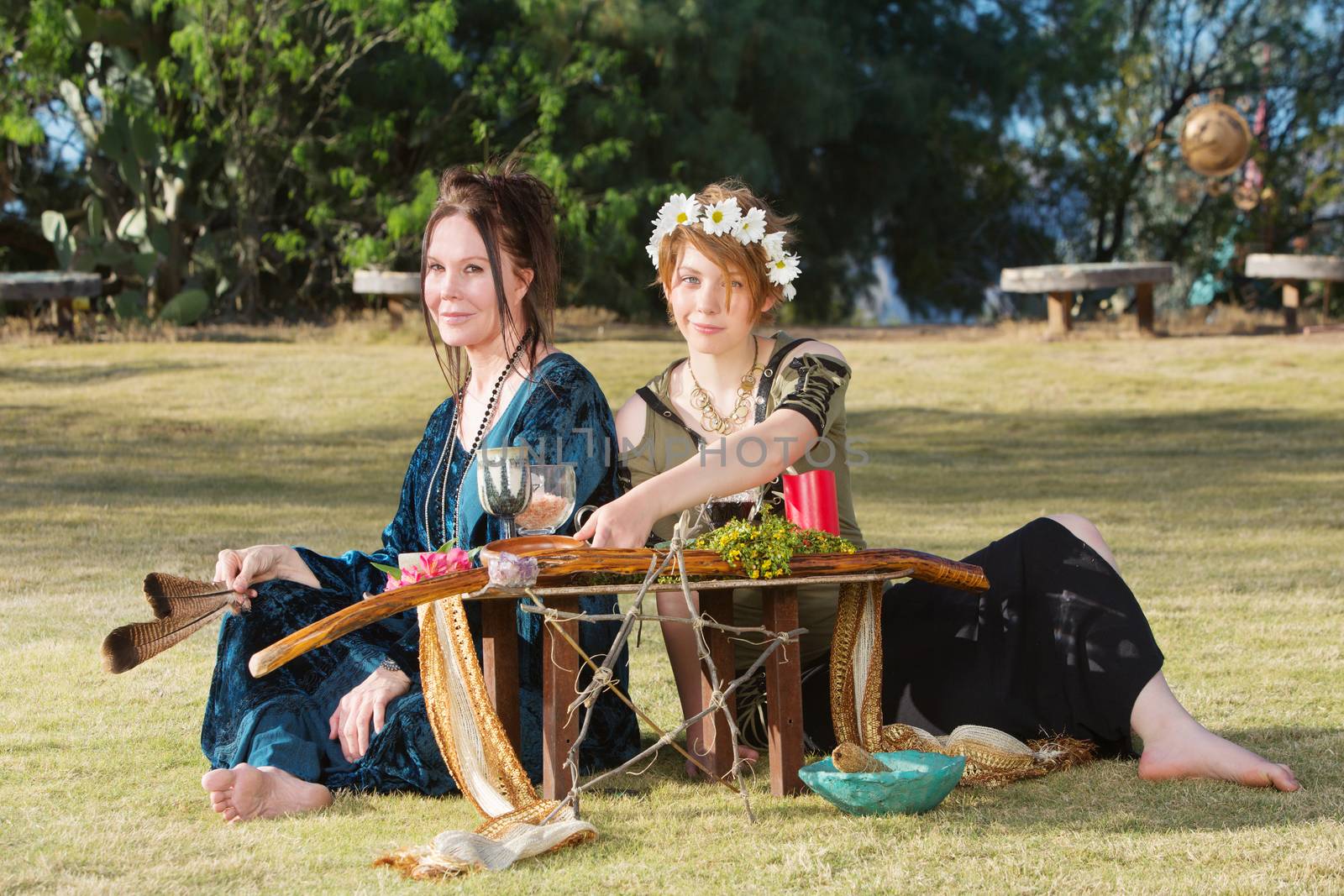 Pair of beautiful pagan women at outdoor altar