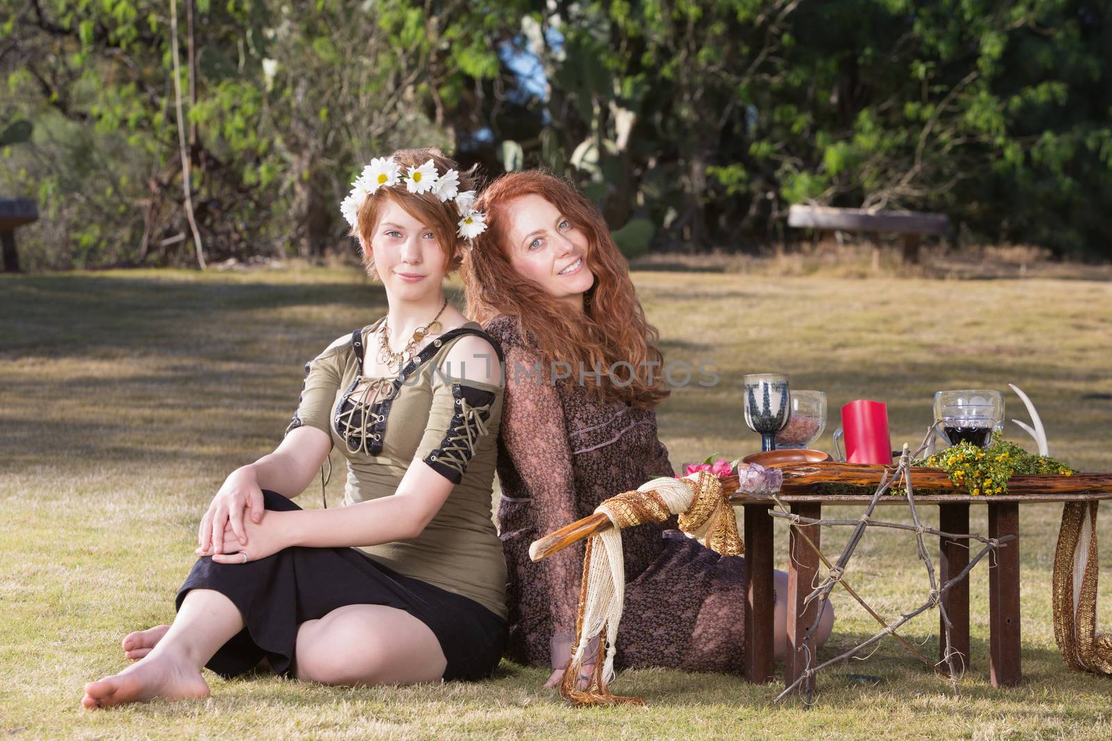 Two smiling pagan women at outdoor altar with pentagram