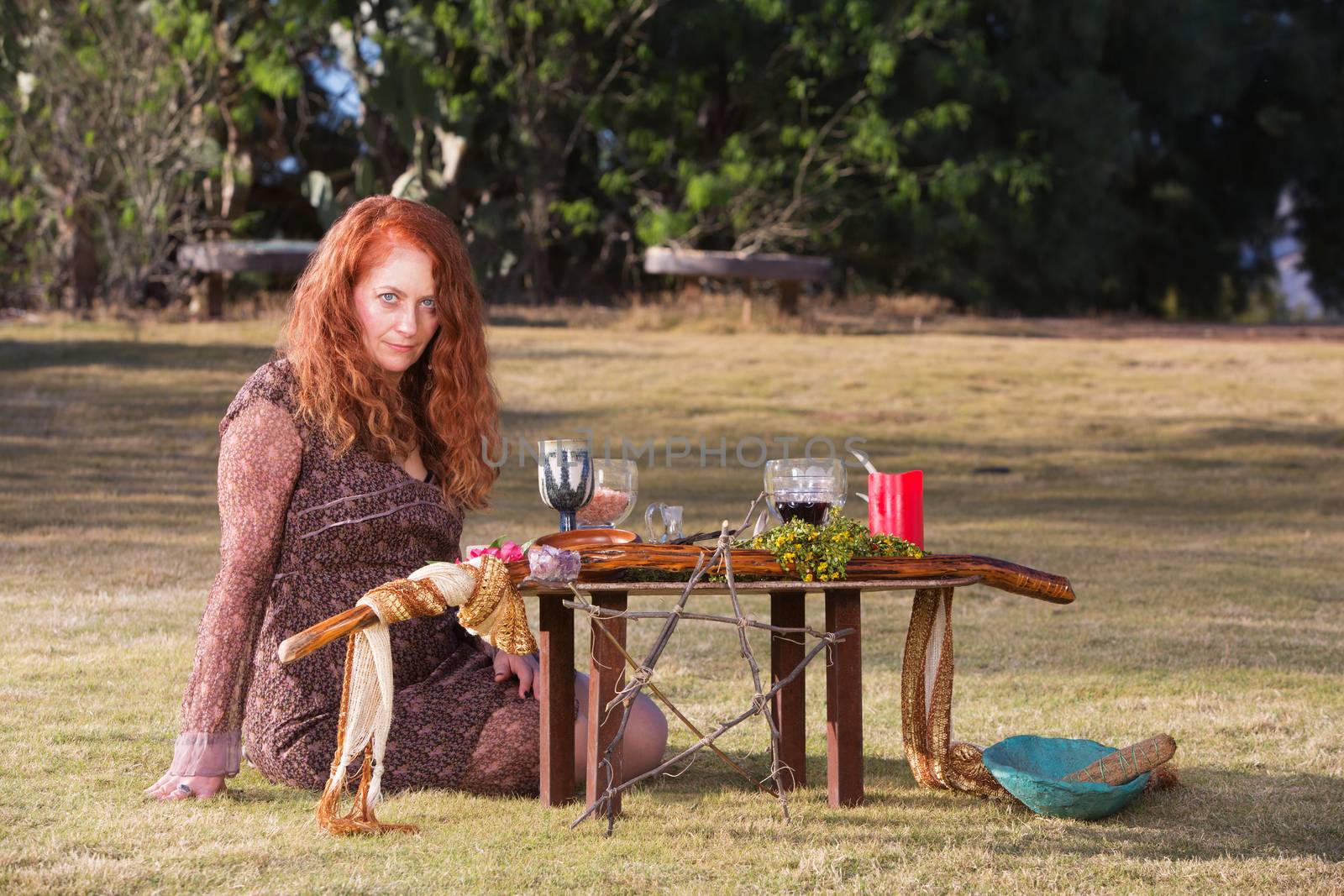 Beautiful priestess in outdoor pagan ritual with altar