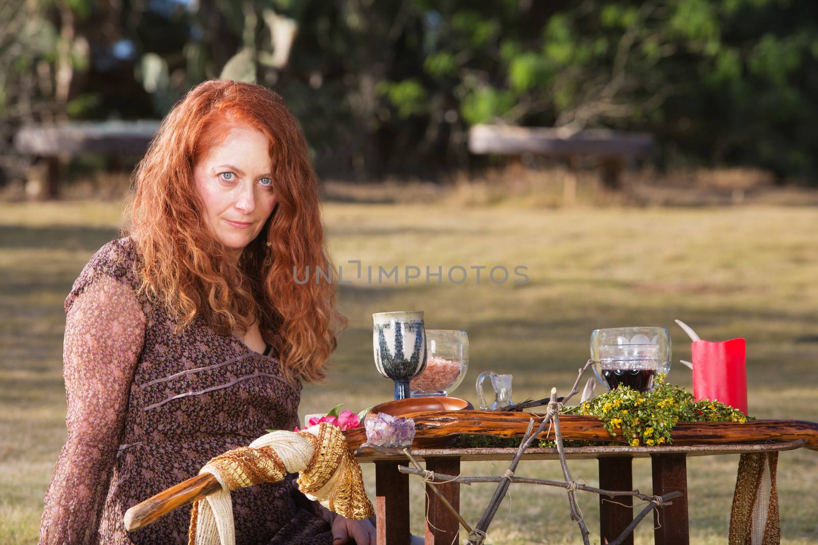 Female Wicca priestess with staff and goblets on altar