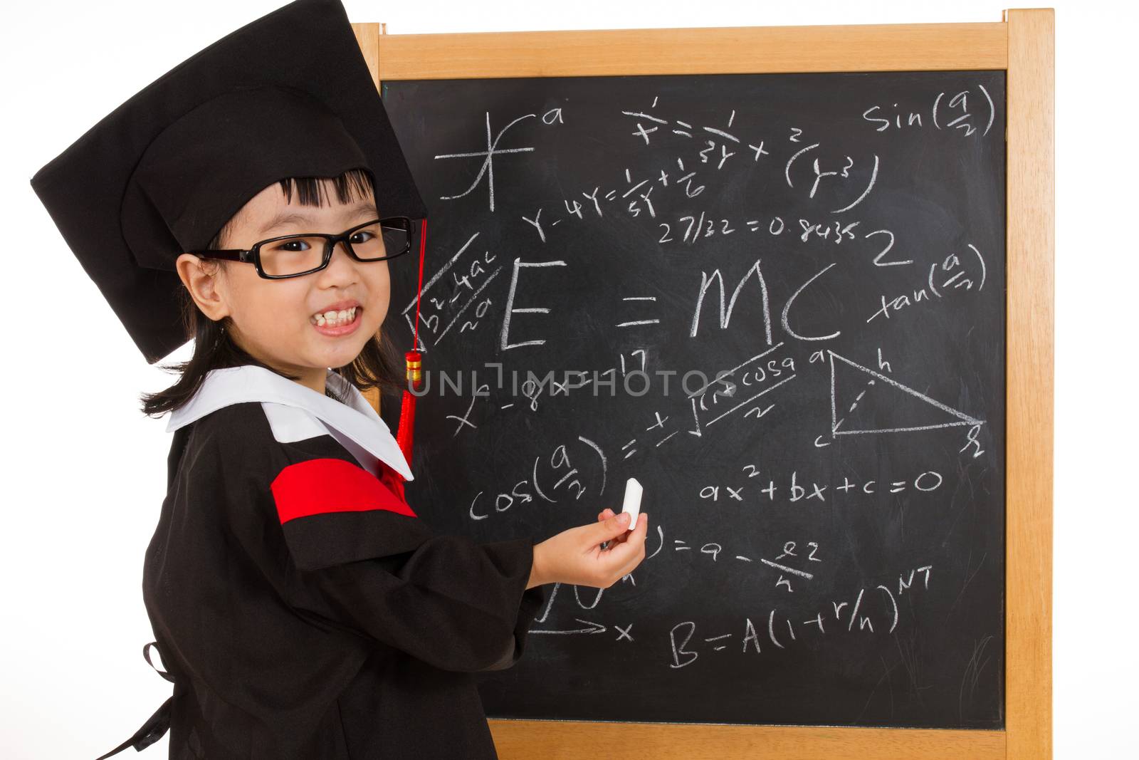 Asian Chinese little girl in graduation gown againts blackboard  by kiankhoon