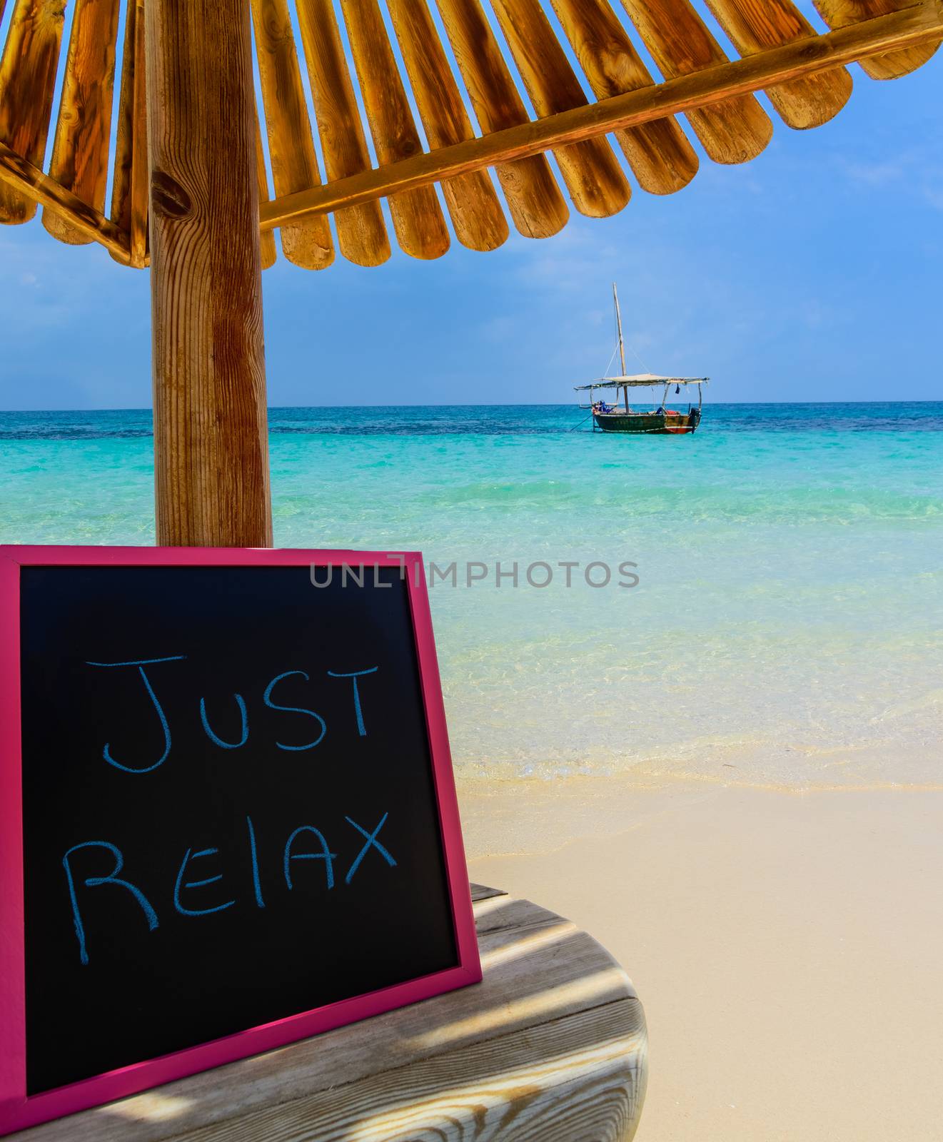 In the picture a Zanzibar beach which is a small blackboard with the words " Just relax" in the afternoon .