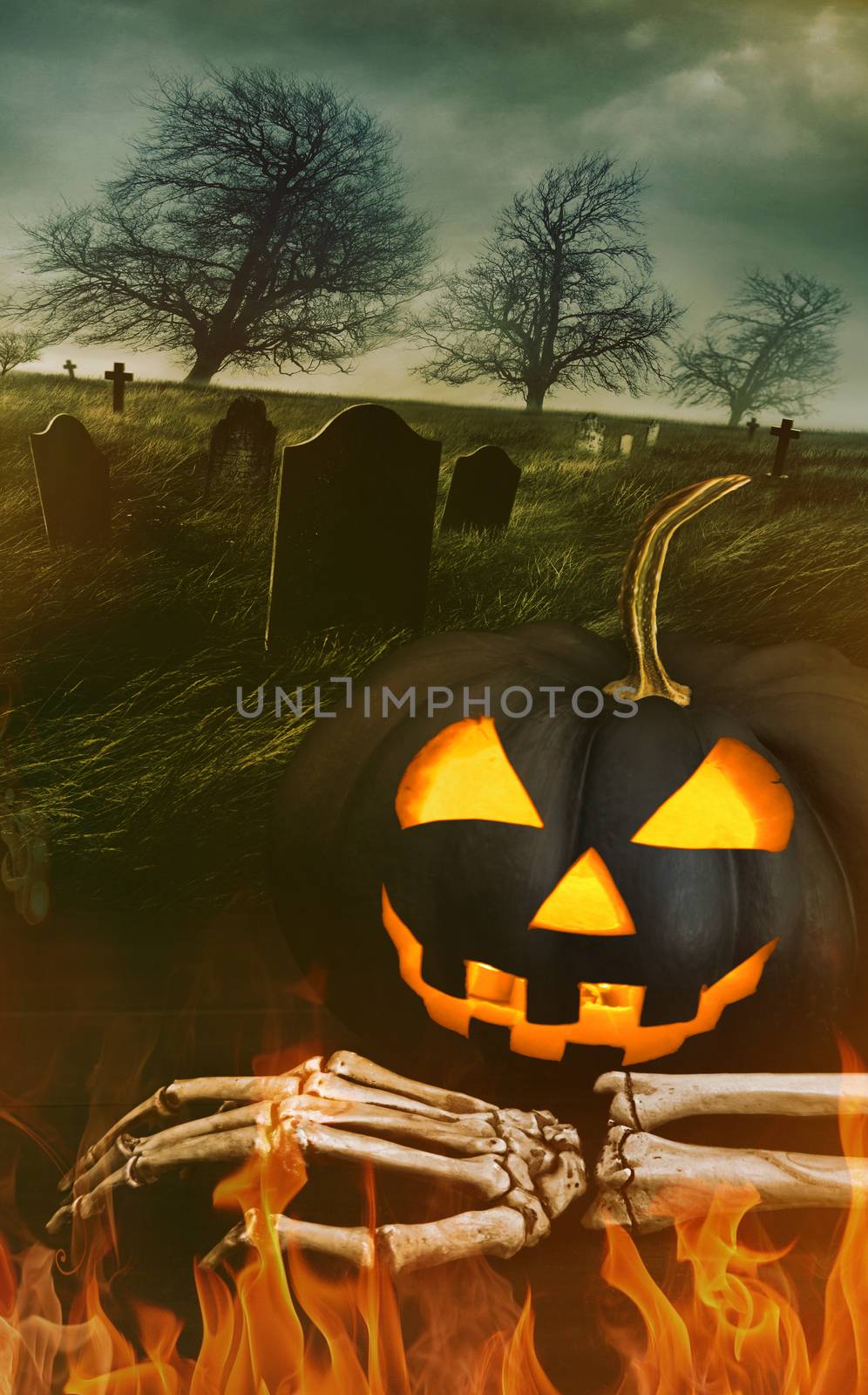 Black pumpkin with skeleton hand with graveyard in background