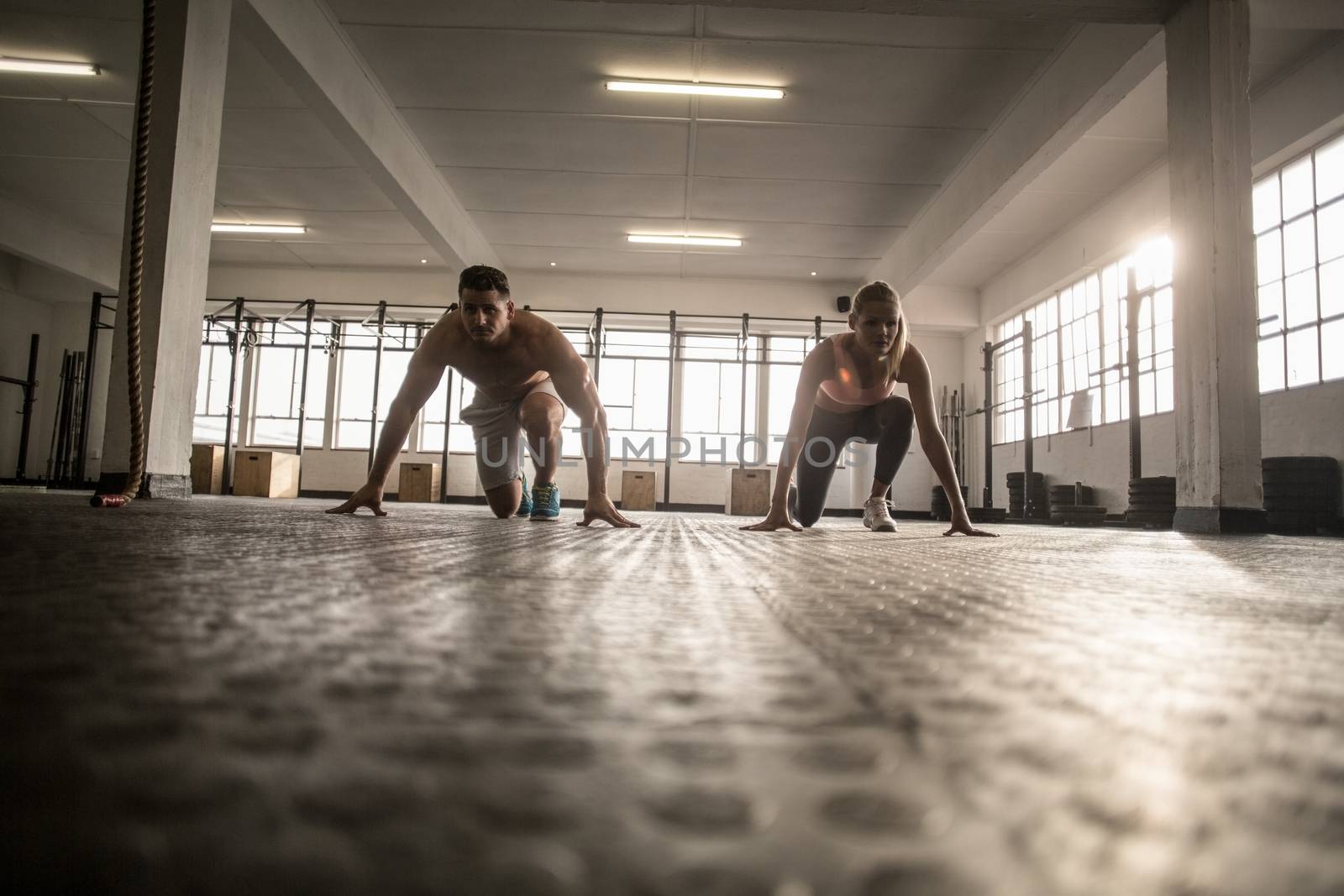 Two fit people doing fitness in crossfit gym