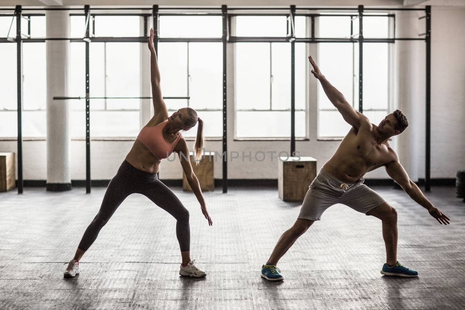 Two fit people doing fitness in crossfit gym