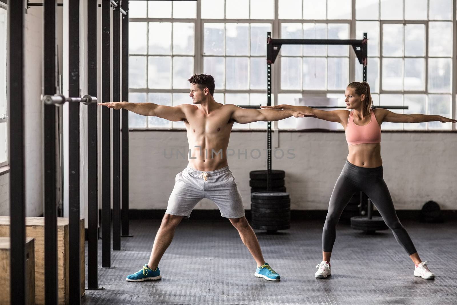 Two fit people doing fitness in crossfit gym