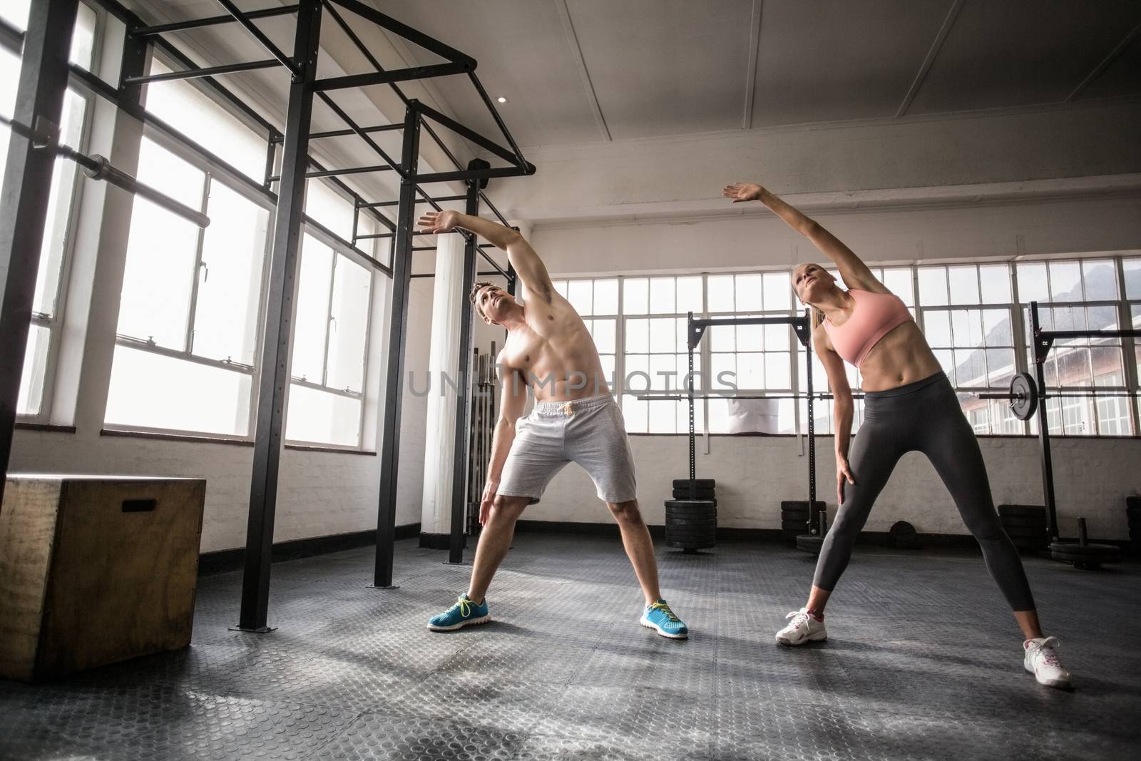 Two fit people doing fitness In crossfit gym