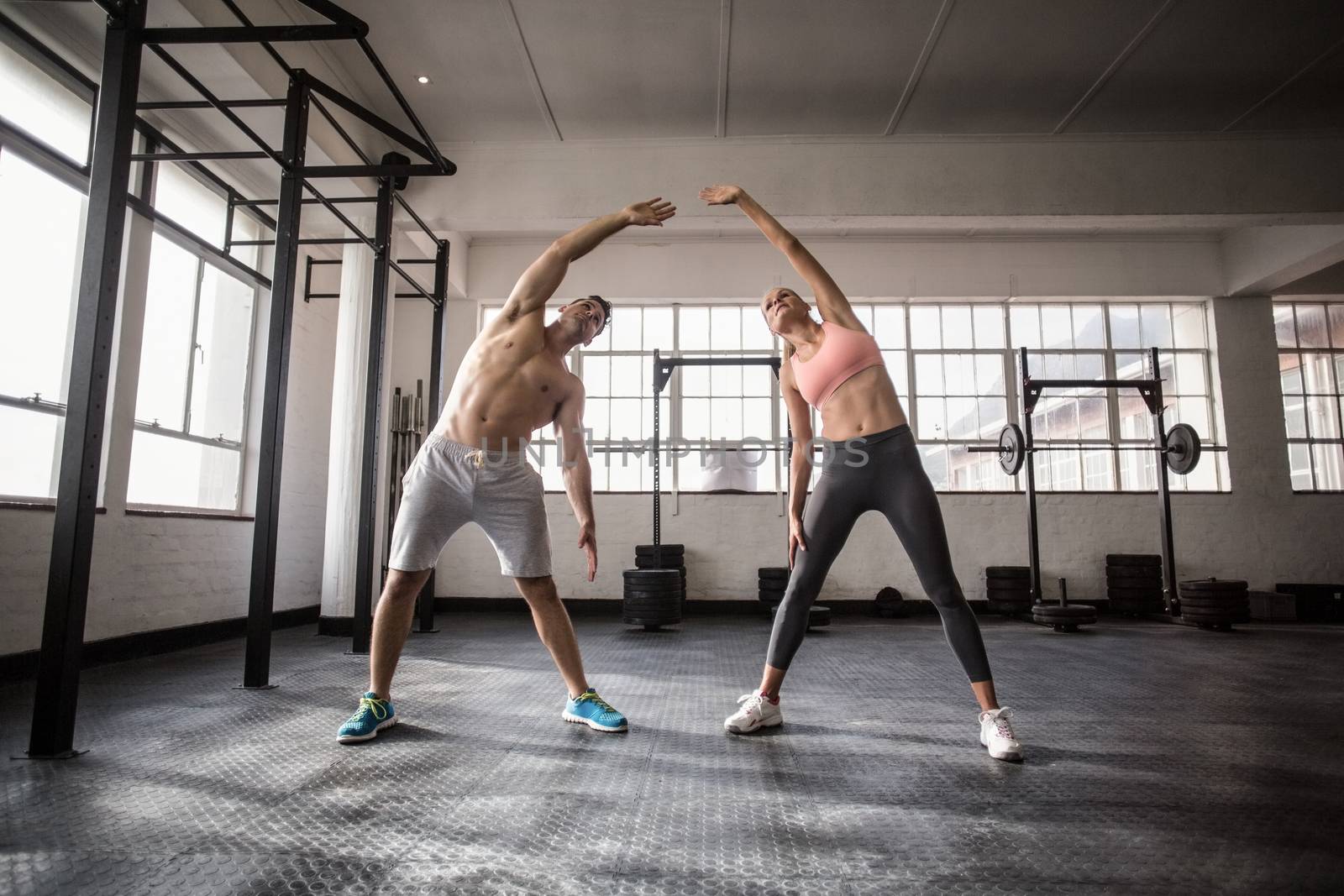 Two fit people doing fitness in crossfit gym