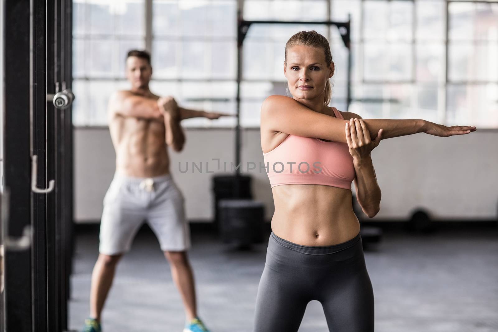 Two fit people doing fitness in crossfit gym