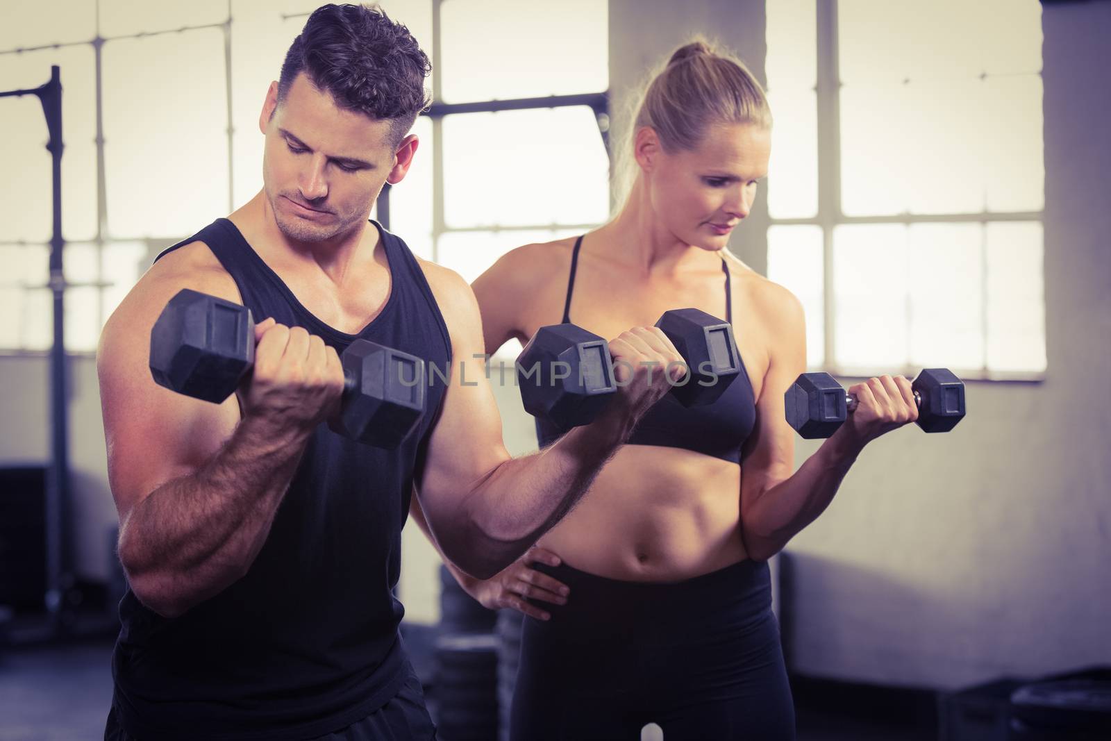 Serious people lifting dumbbell at the gym