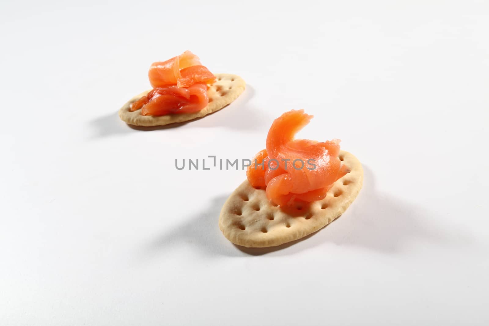 two cracker with salmon on white background