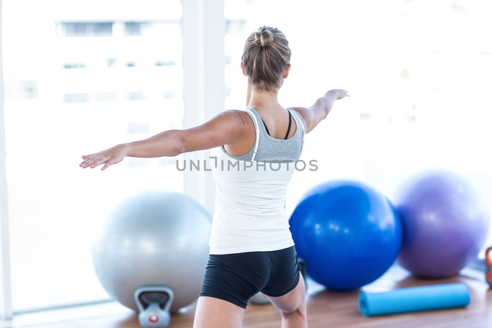 Attractive woman with arms outstretched in fitness studio