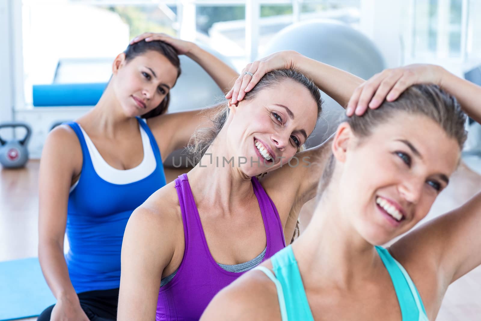 Portrait of woman doing head exercise with her friends by Wavebreakmedia