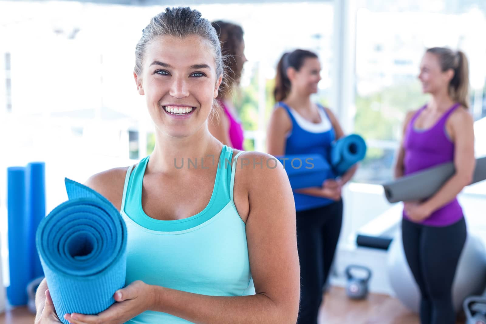 Portrait of cheerful woman with friends at fitness studio by Wavebreakmedia