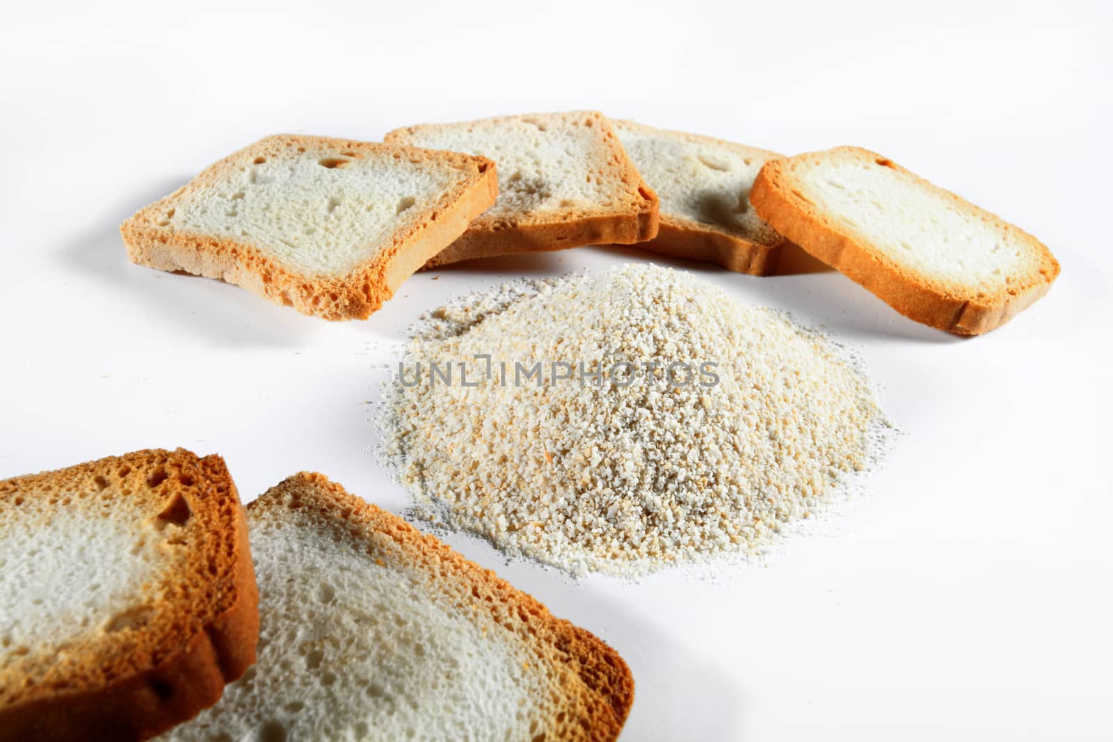 bread crumbs and biscuits on white background by diecidodici