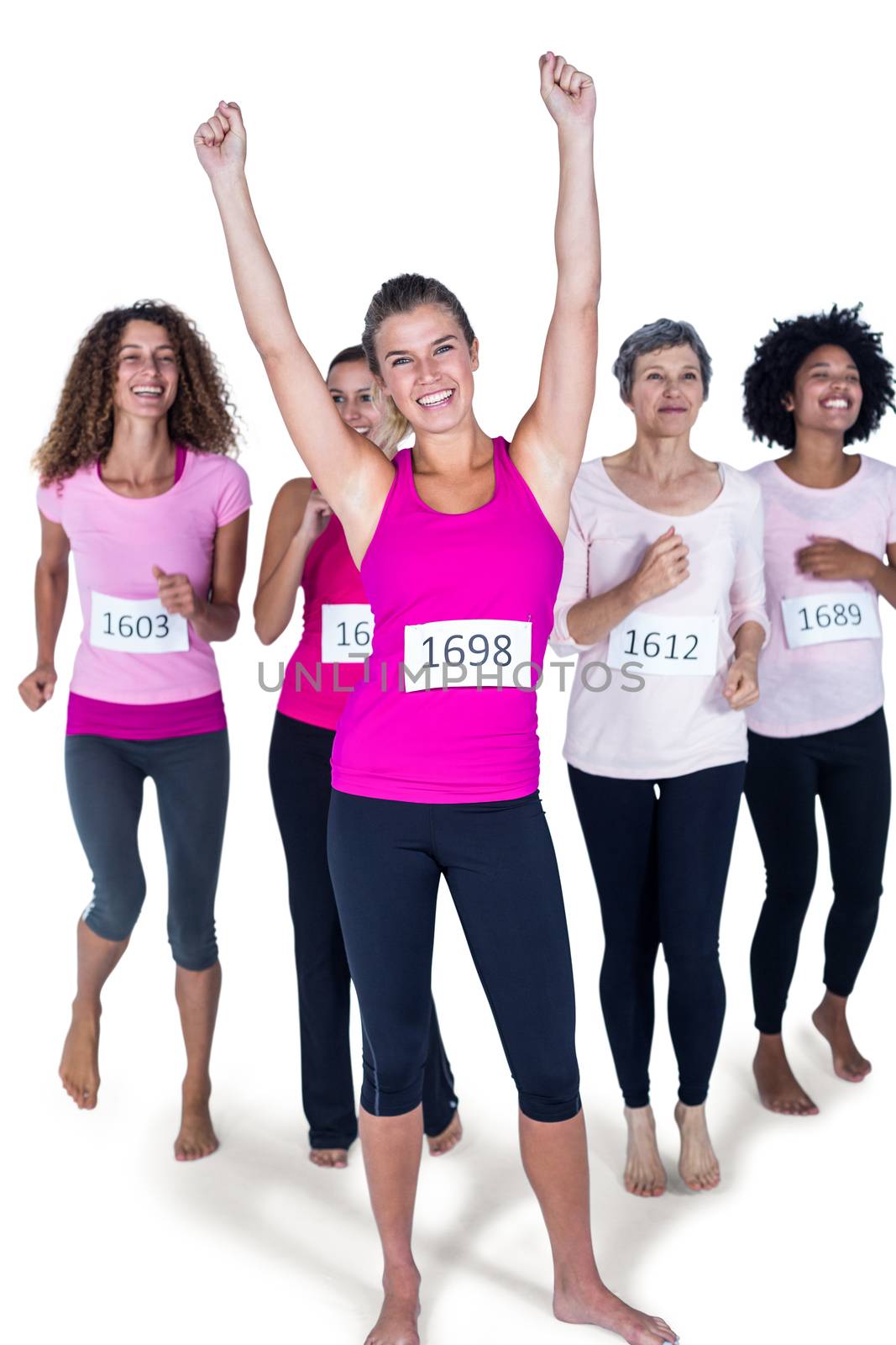Full length portrait of smiling winner athlete with arms raised and others running against white background