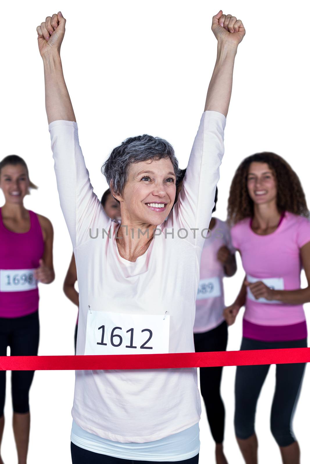 Happy winner athlete crossing finish line with arms raised against white background