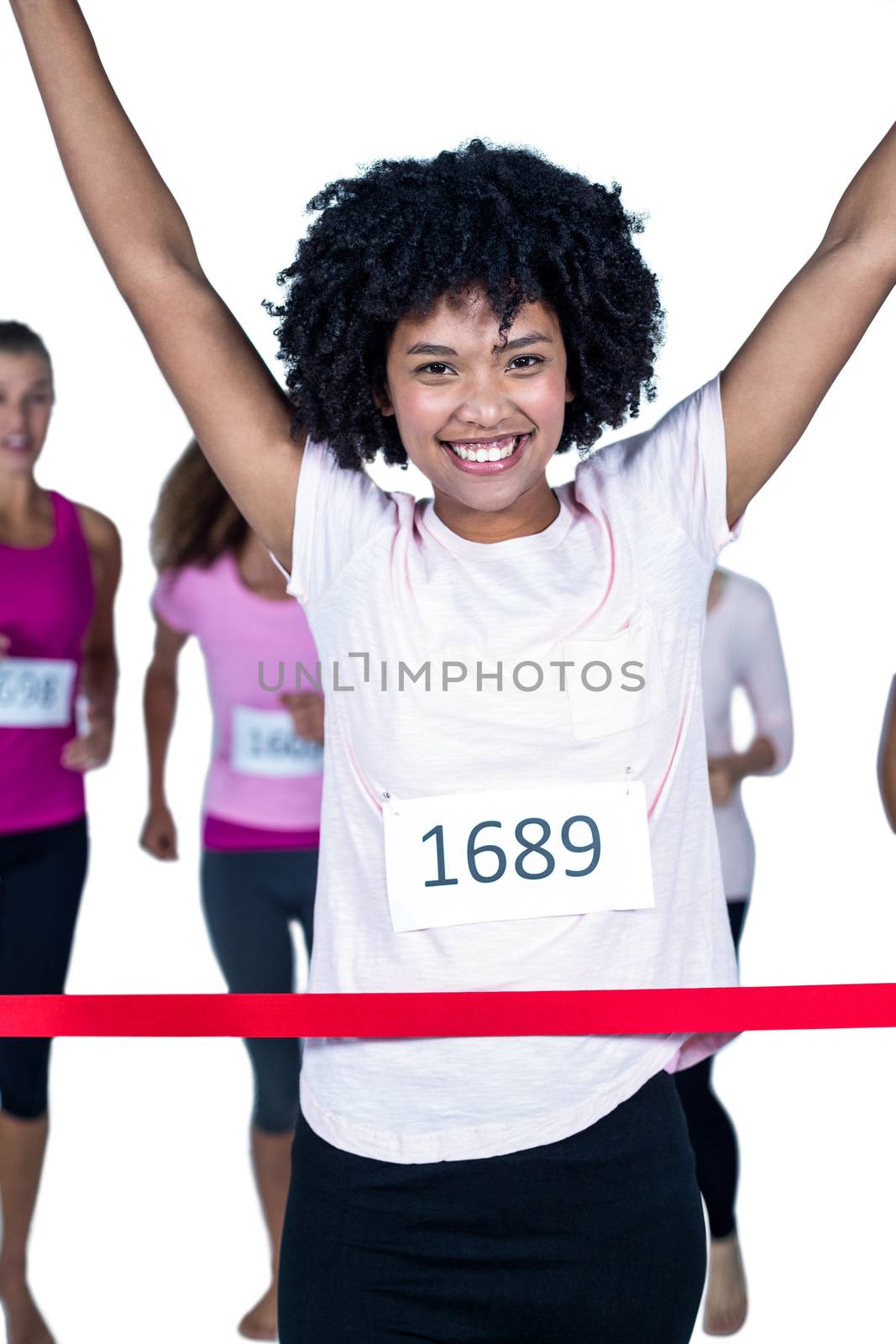 Portrait of happy winner female athlete crossing finish line with arms raised  by Wavebreakmedia